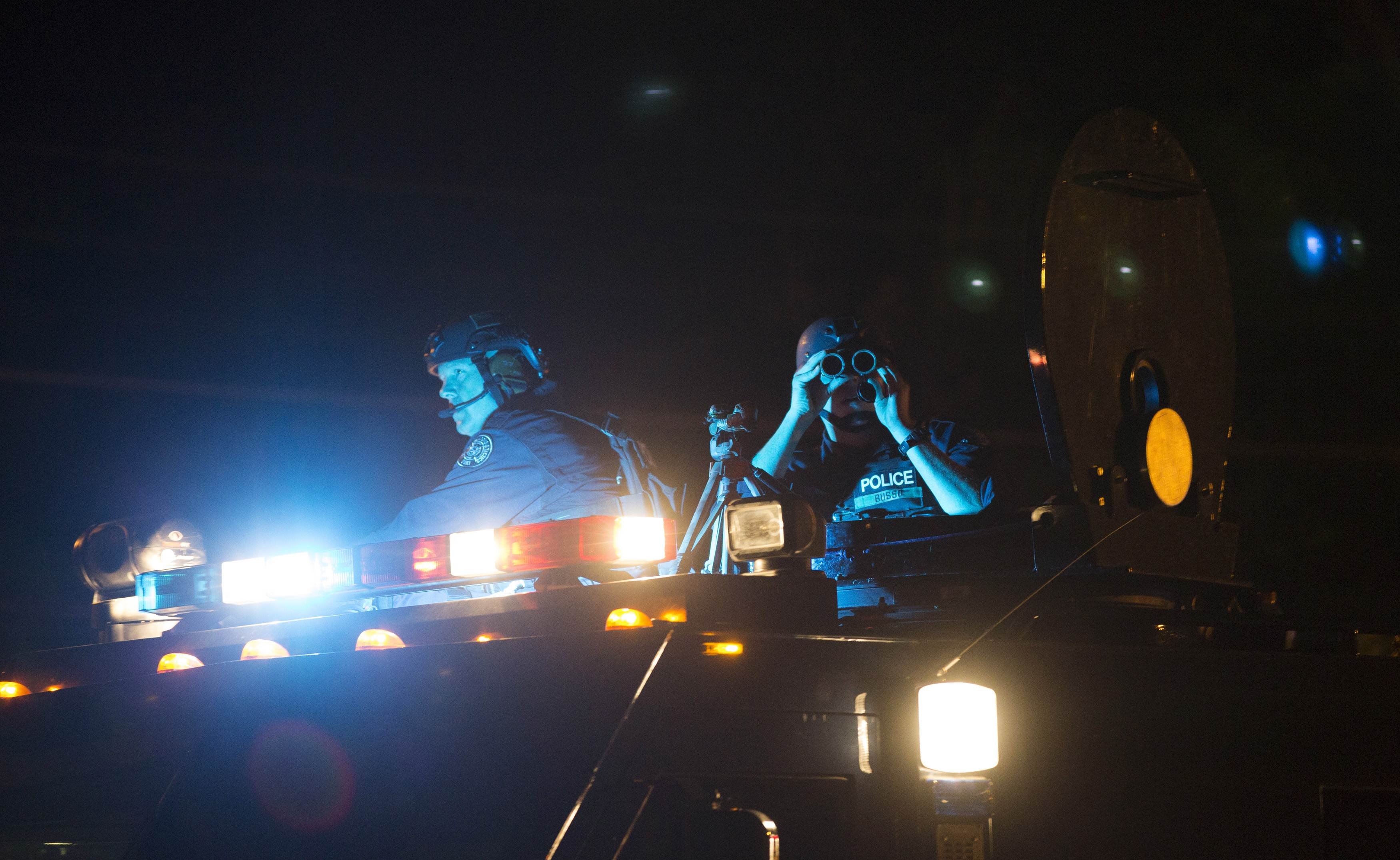 Police officers keep watch from an armored vehicle as they patrol a street in Ferguson, Mo., on Aug. 11, 2014 (Mario Anzuoni—Reuters)
