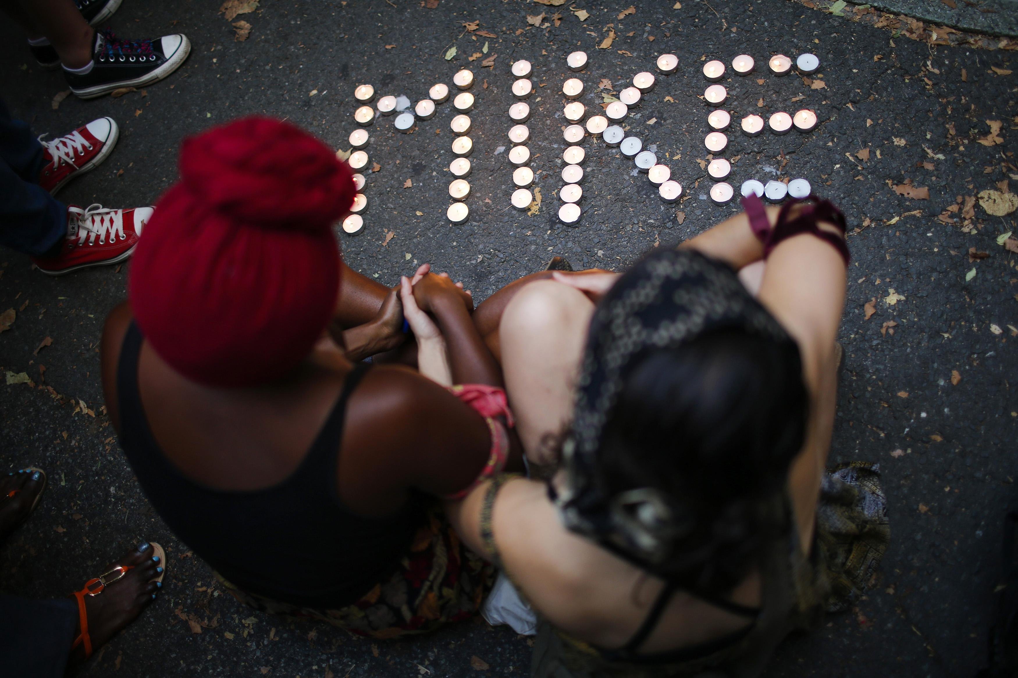 People attend a vigil to honor Michael Brown, who was shot and killed by an unnamed police officer last Saturday in Ferguson, Missouri, in Brooklyn on Aug. 14, 2014.