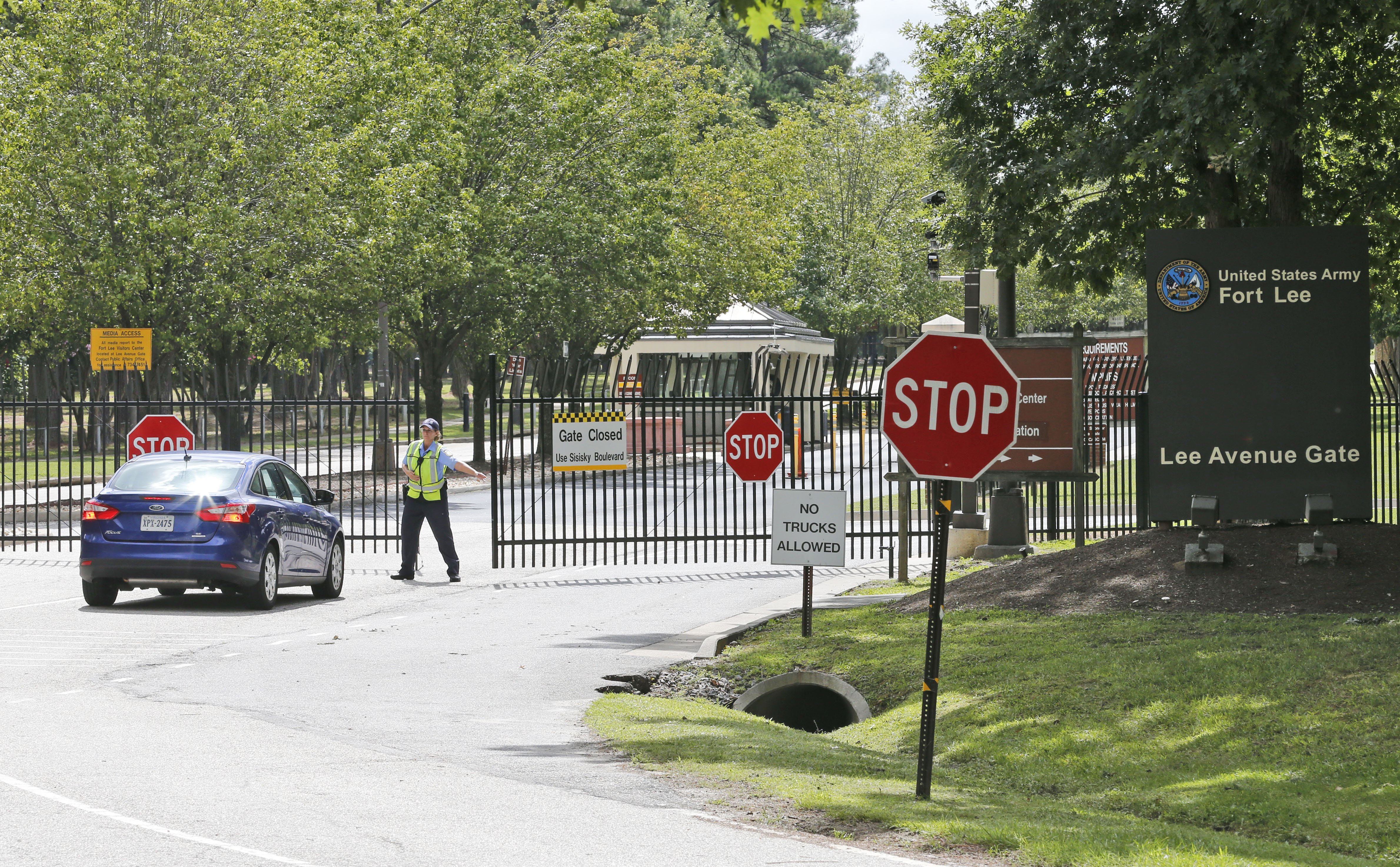 Security guards open a gate for motorist at the visitor entrance to Fort Lee, Va. on Aug. 25, 2014.  