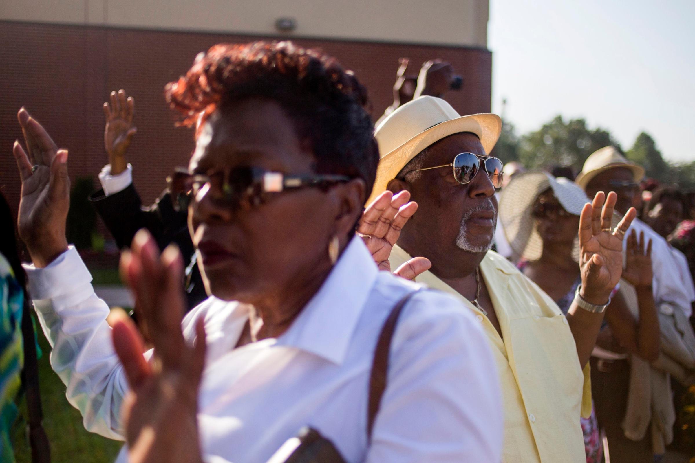 Attendees hold their hands up as some chant "Hands up don't shoot," while they wait in line to take part in the funeral services for 18-year-old Michael Brown at the Friendly Temple Missionary Baptist Church in St. Louis, Missouri