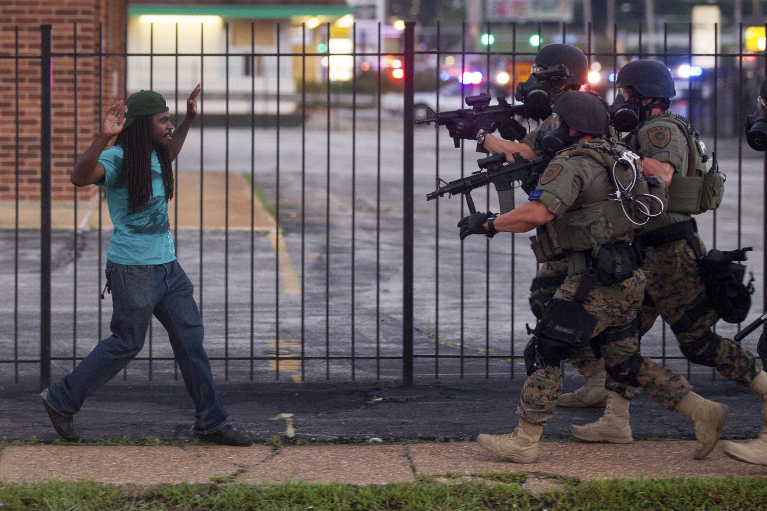 Aug. 11, 2014. A man backs away as law enforcement officials close in on him and eventually detain him during protests over the death of Michael Brown, an unarmed black teenager killed by a police officer, in Ferguson, Mo.