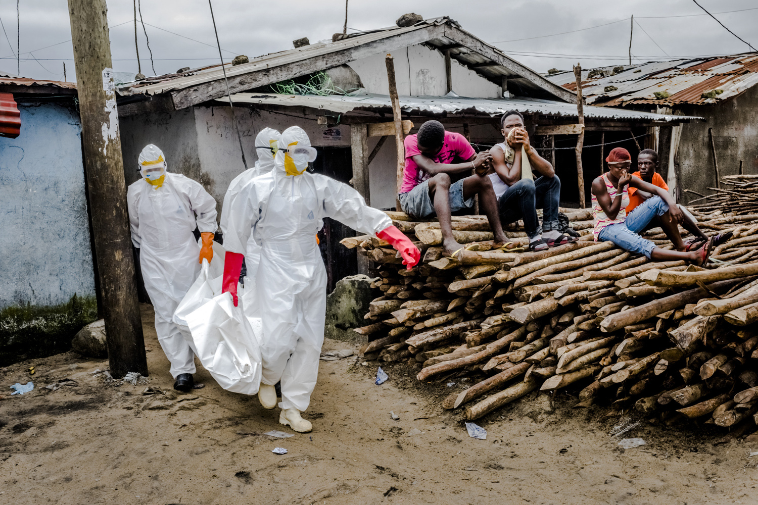 A burial team in protective clothing removes the body an Ebola victim from an isolation ward in Monrovia, Liberia.