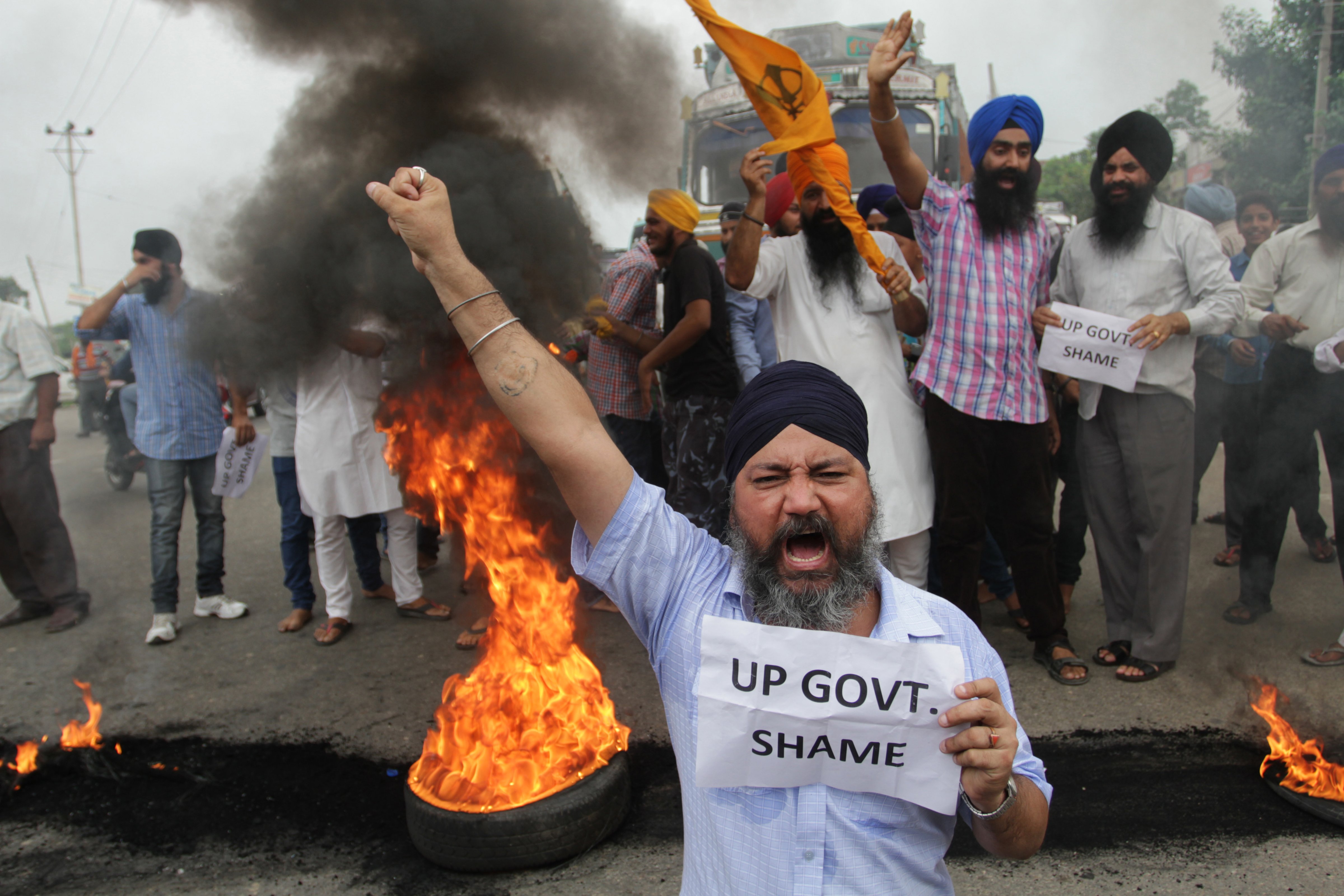 Members of the Sikh community shout slogans as they burn tires during a protest in the Indian state of Uttar Pradesh on July 27, 2014. (Jaipal Singh—EPA)