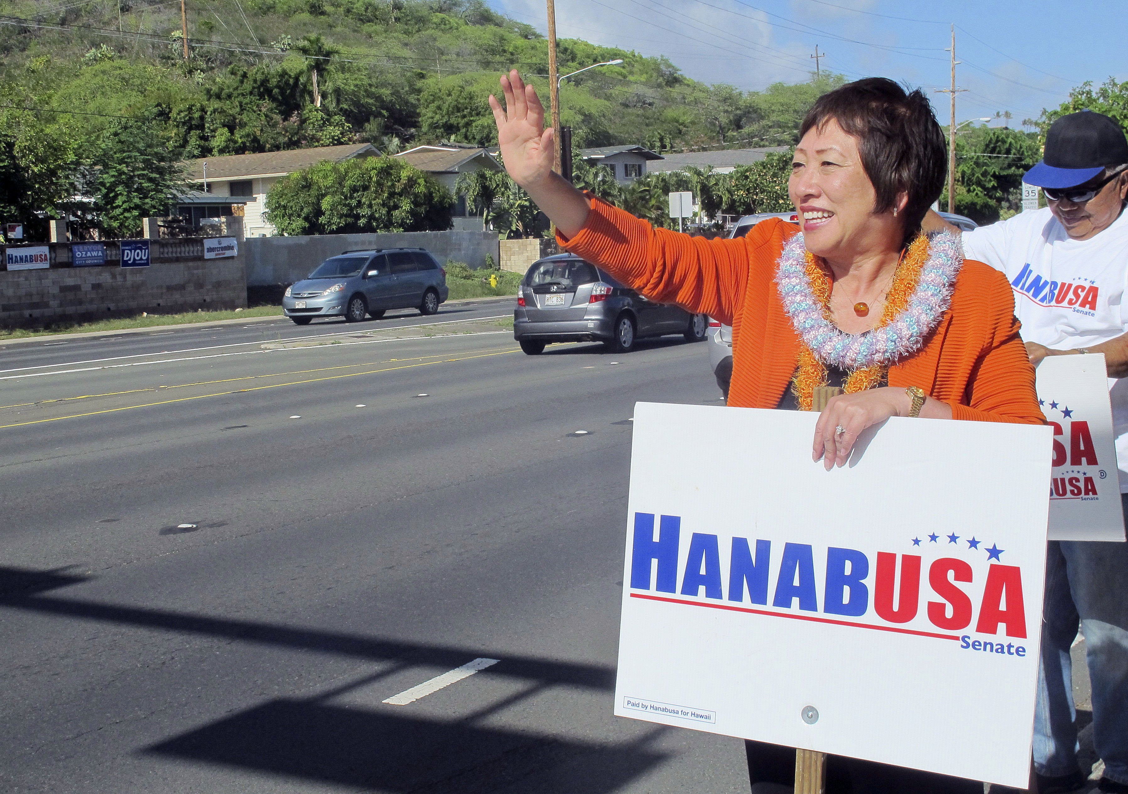 U.S. Rep. Colleen Hanabusa waves at drivers while campaigning for U.S. Senate in Honolulu on Aug. 4, 2014. (Audrey McAvoy—AP)