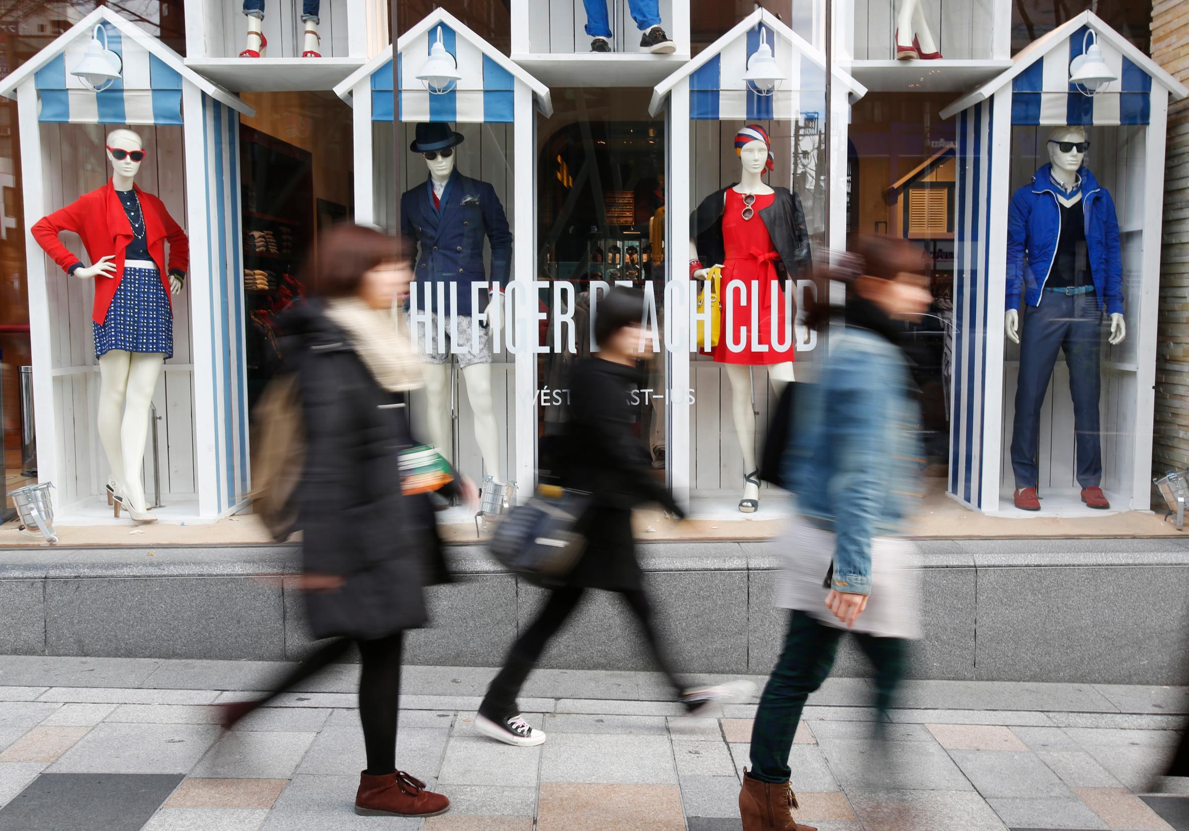 Pedestrians walk past a show window of a clothing store at Harajuku shopping district in Tokyo February 28, 2014. J
