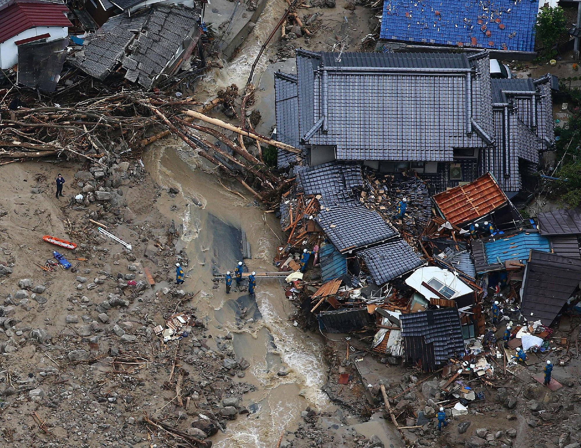 This aerial view shows rescue workers looking for survivors at the site of a landslide after heavy rains hit the city of Hiroshima, western Japan, on Aug. 20, 2014.