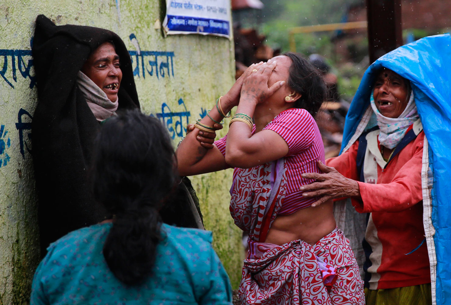 Relatives wail after seeing the body of a victim after a massive landslide in Malin village in Pune district of western Maharashtra state, India on July 31, 2014.
