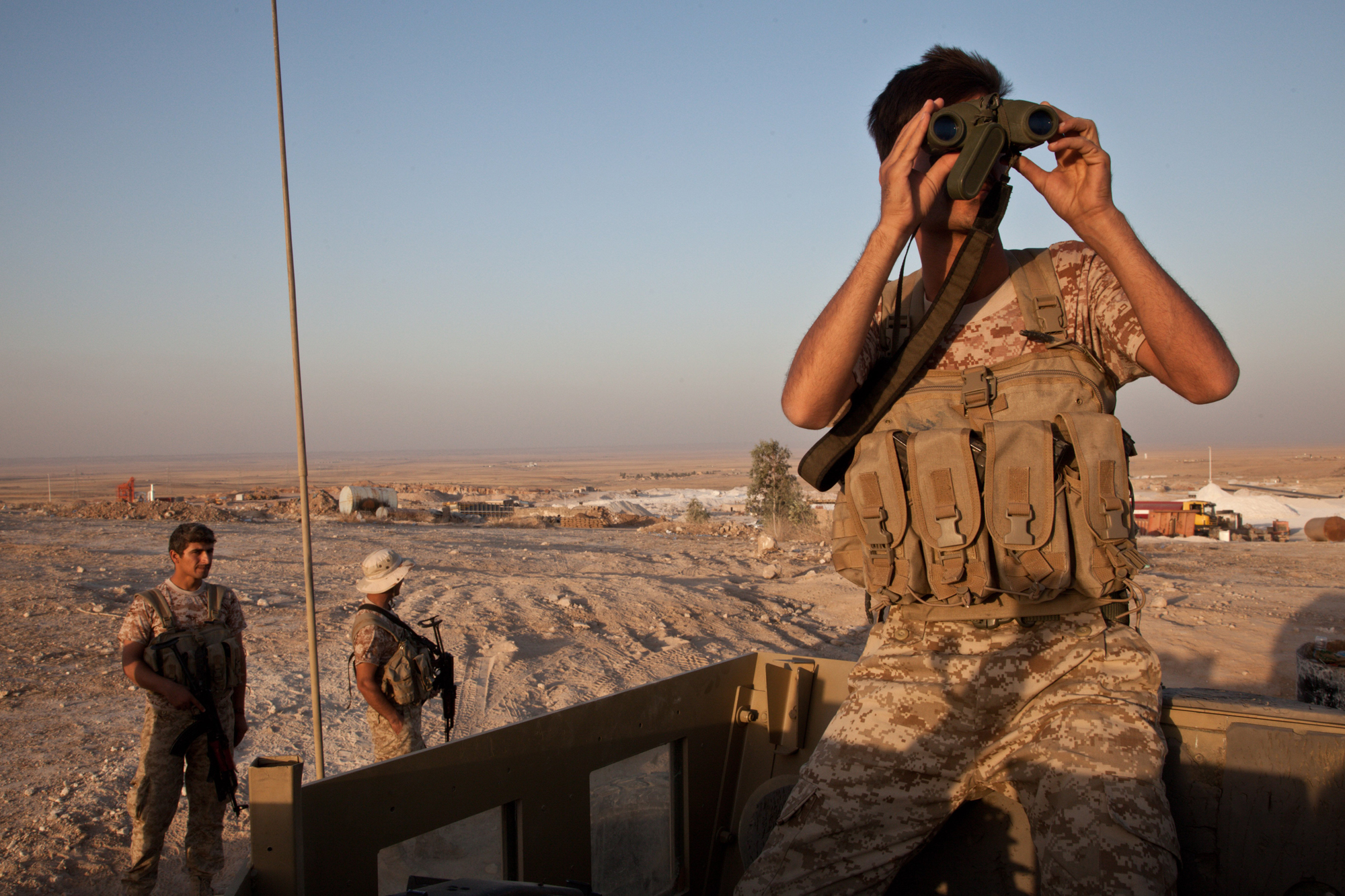 A Kurdish peshmerga soldier looks out over the town of Makhmour from defensive positions, Aug. 11, 2014.