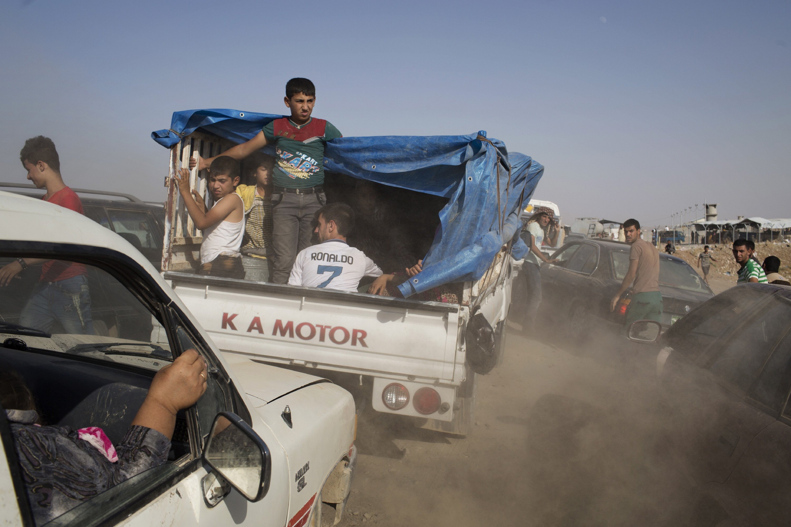 Iraqis arrive at a Kurdish peshmerga controlled checkpoint between Irbil and Mosul after fleeing in fear of ISIS attacks, Aug. 6, 2014. (Adam Ferguson—The New York Times/Redux)