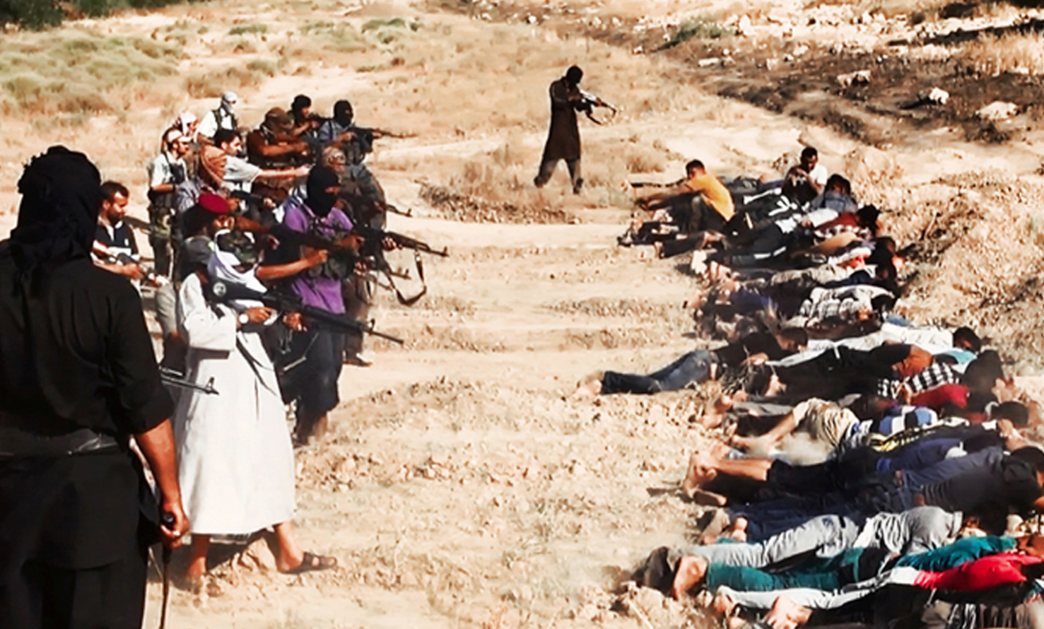 Image posted on a militant website on June 14, 2014, which has been verified and is consistent with other AP reporting, appears to show militants from the al-Qaida-inspired Islamic State of Iraq and the Syria (ISIS) taking aim at captured Iraqi soldiers wearing plain clothes after taking over a base in Tikrit, Iraq.