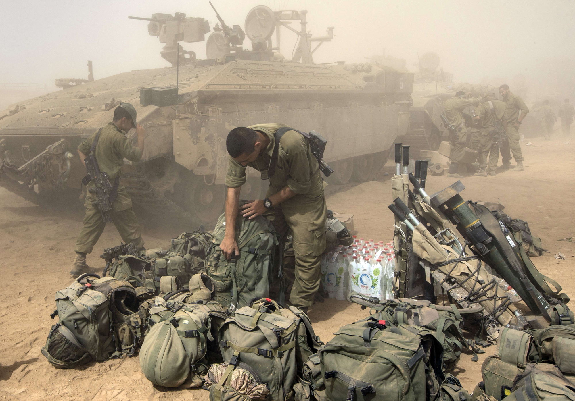 An Israeli soldier prepares his equipment at an army deployment area, on the southern Israeli border with the Gaza Strip, on August 1, 2014.