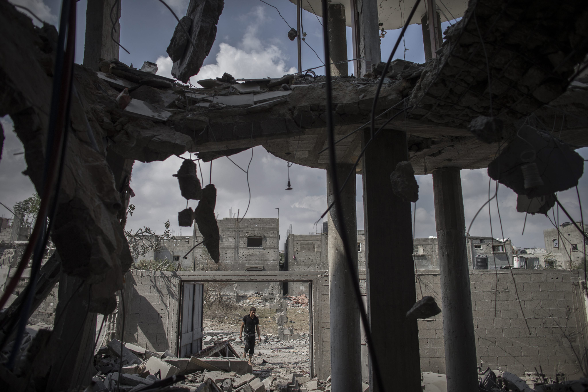 A Palestinian man enters his destroyed home in Beit Hanoun, northern Gaza Strip, August 5, 2014. (Oliver Weiken—EPA)