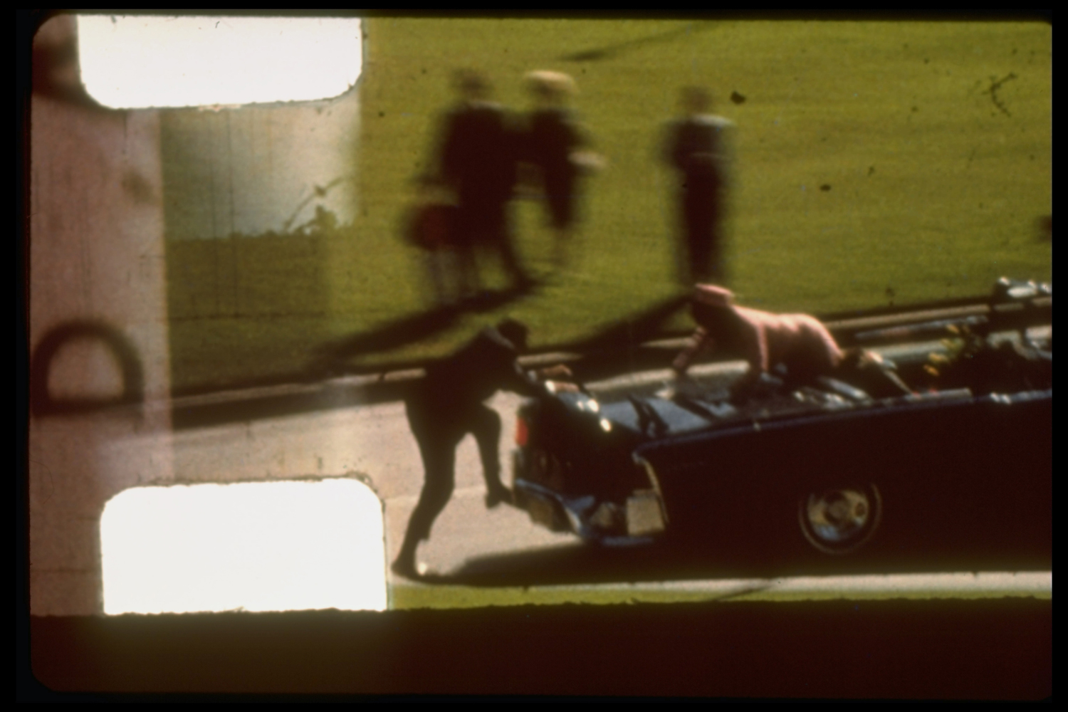 Zapruder film frame #372 of Kennedy assassination showing Mrs. Kennedy climbing towards Secret Service agent who is attempting to board back of limousine after Pres. Kennedy has been shot. Dallas. United States. Nov. 22, 1963.