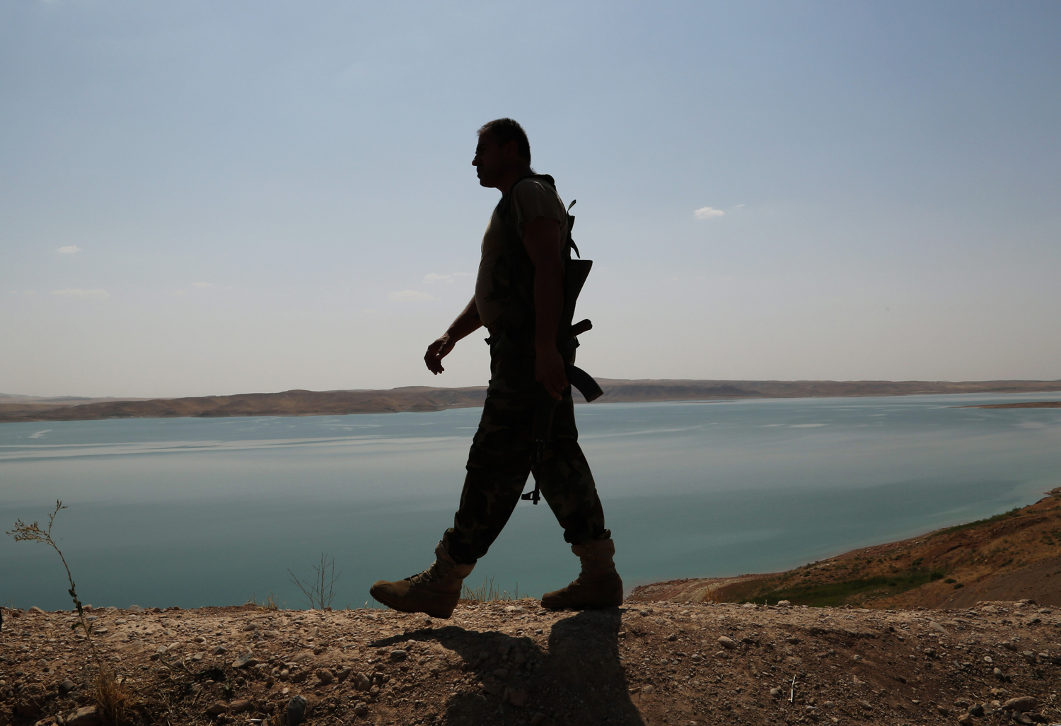 A Kurdish peshmerga fighter patrols near the Mosul Dam at the town of Chamibarakat outside Mosul, Iraq on Sunday, Aug. 17, 2014. (Khalid Mohammed&mdash;AP)