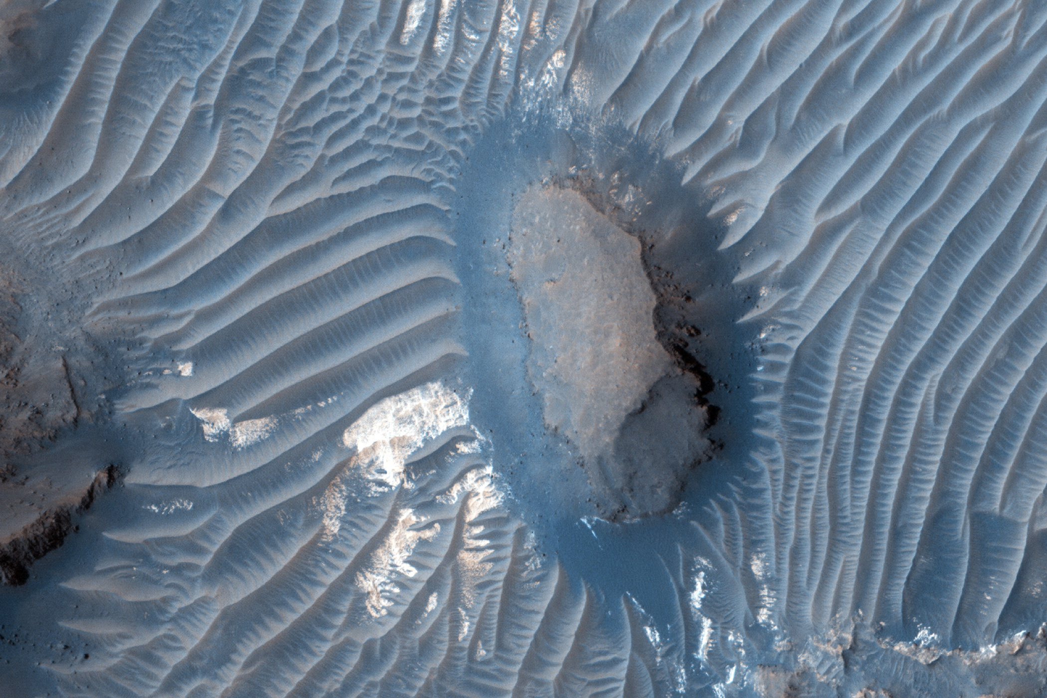 This image is located within Aram Chaos near the outlet to Ares Valles. Aram Chaos is a 1300 kilometer (approximately 800 miles) diameter depression from which enormous cataclysmic releases of ground water are thought to have exploded onto the surface of Mars. The water then flowed northwards across the southern highlands, helping to carve the approximately 2000 kilometer (1200 miles) long Ares Valles outflow channel system.