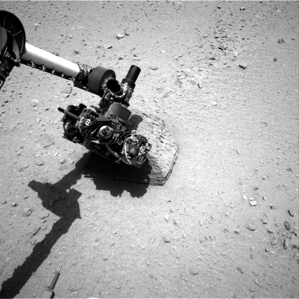 This image shows the robotic arm of NASA's Mars rover Curiosity with the first rock touched by an instrument on the arm.