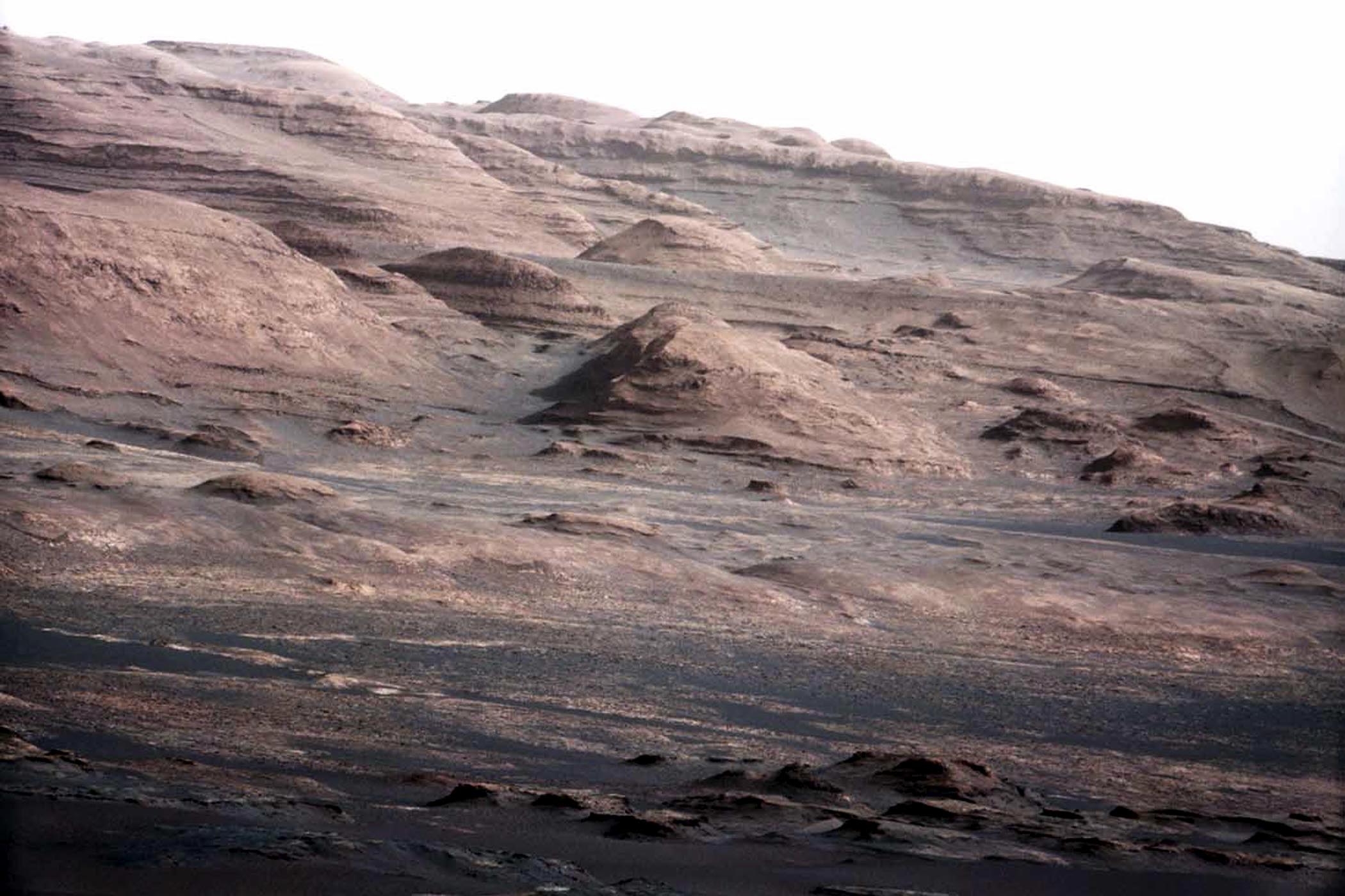 A detailed telephoto view from Curiosity shows Mount Sharp. The rover was expected to reach the 3.4-mile-high peak in February 2013, and the layered surface of the mountain should yield information to scientists on the planet's geological history.