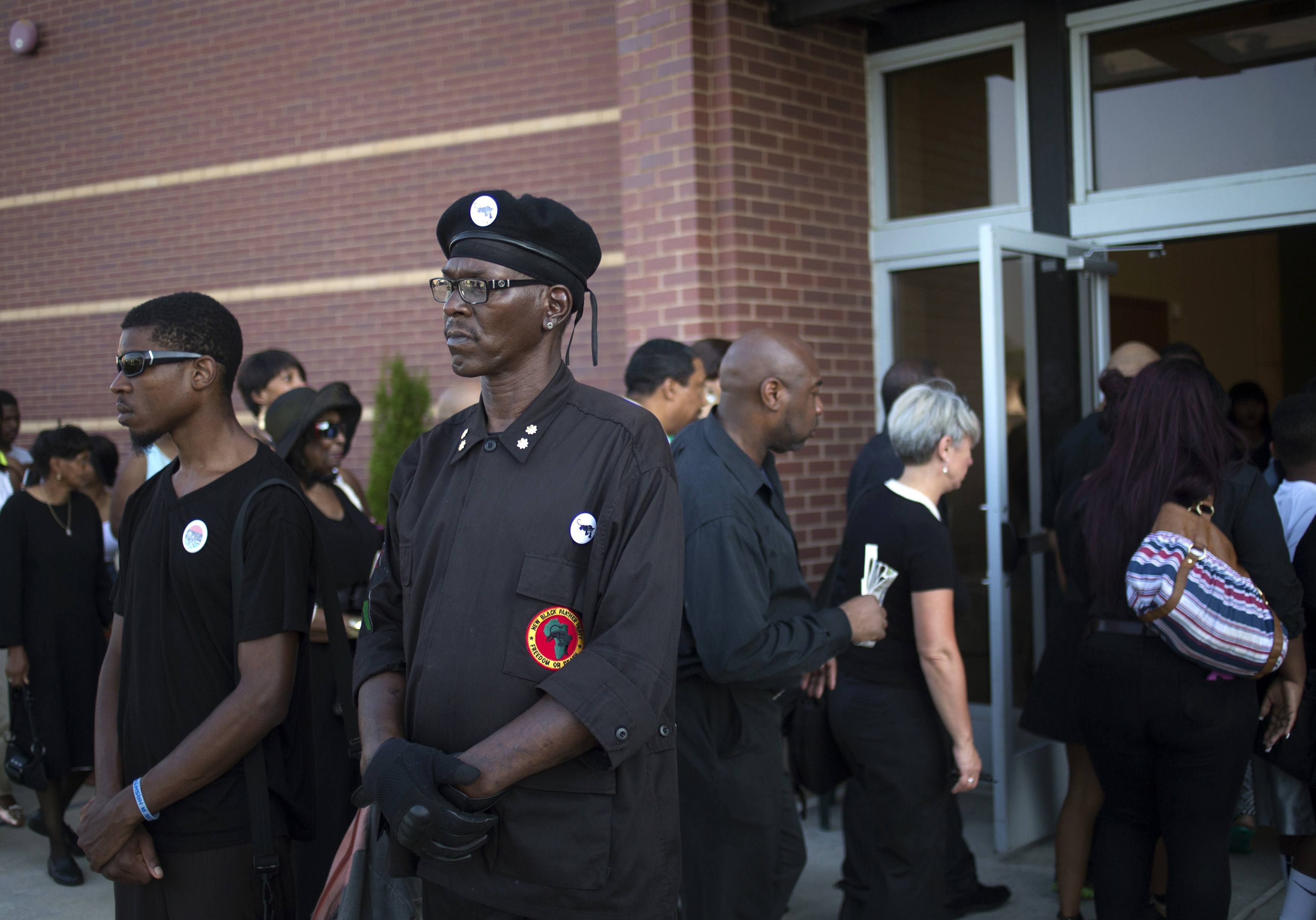 Members of the New Black Panther Party for Self-Defense (NBPP) stand guard in front of the Friendly Temple Missionary Baptist Church in St. Louis on Aug. 25, 2014.