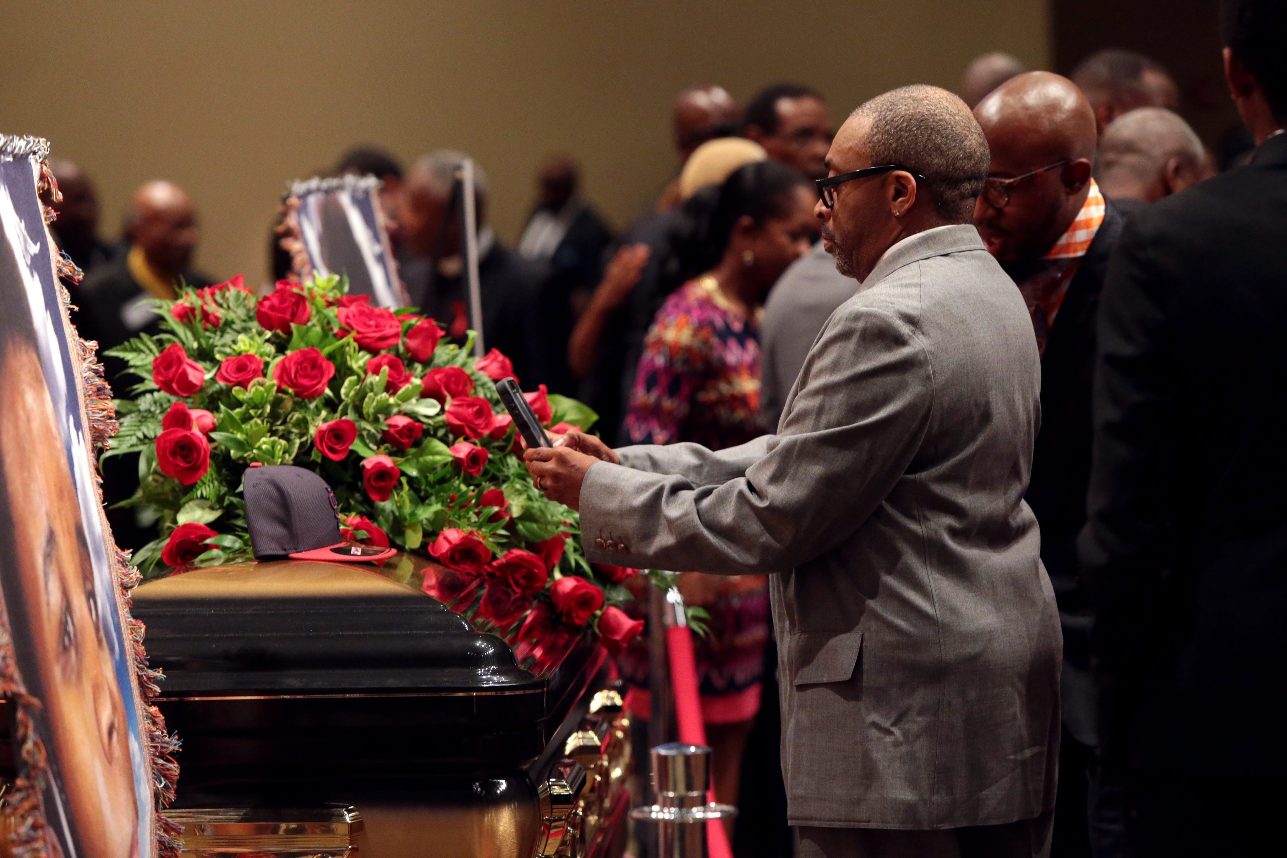 American film director Spike Lee takes a picture of a black St. Louis Cardinals baseball cap on top of Michael Brown's casket during his funeral inside the Friendly Temple Missionary Baptist Church in St. Louis on Aug. 25, 2014.
