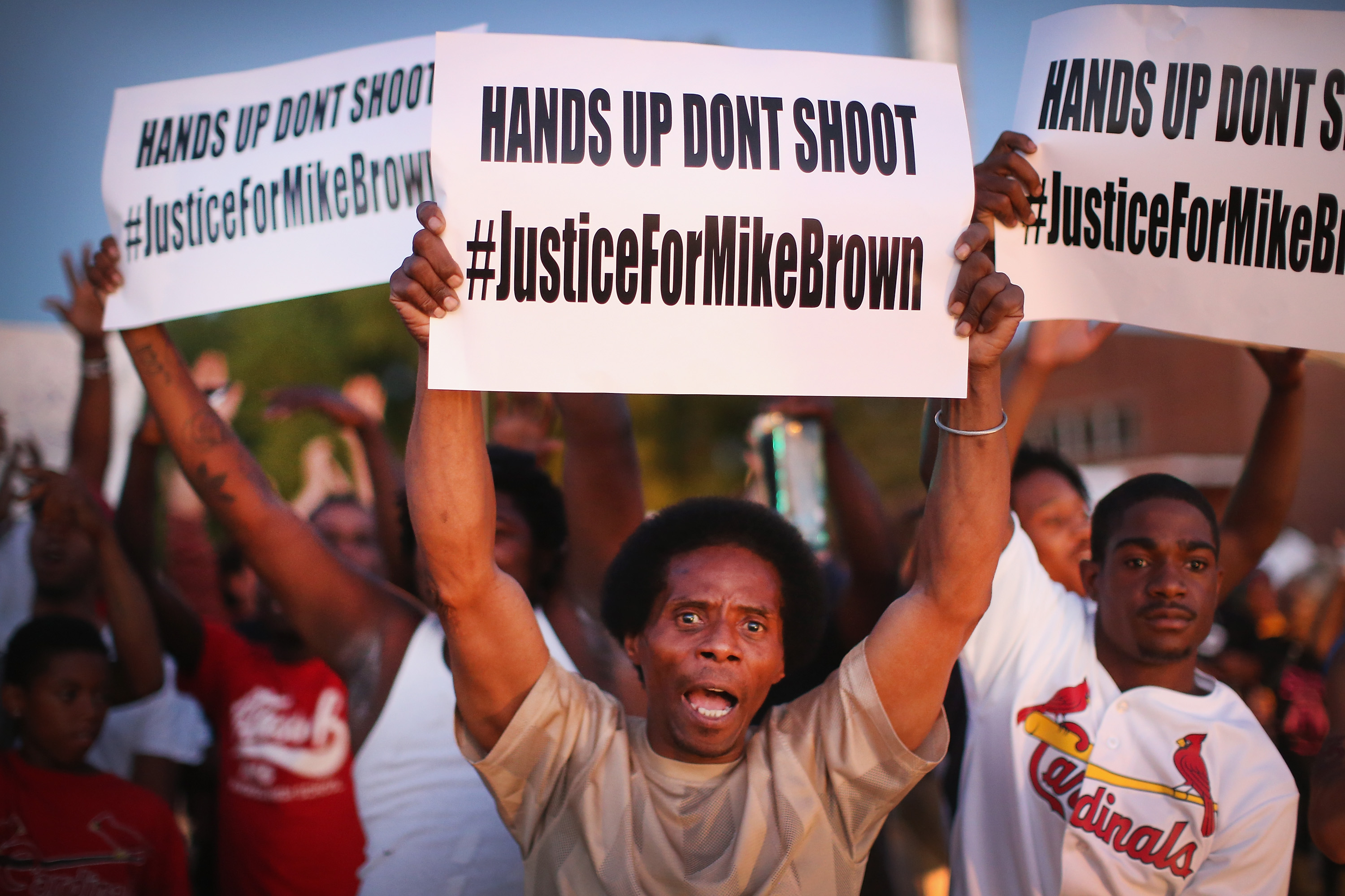 Demonstrators protest the killing of teenager Michael Brown outside Greater St. Marks Family Church, in St. Louis, while his family along with civil rights leader the Rev. Al Sharpton and others met inside to discuss the killing on Aug. 12, 2014 (Scott Olson—Getty Images)