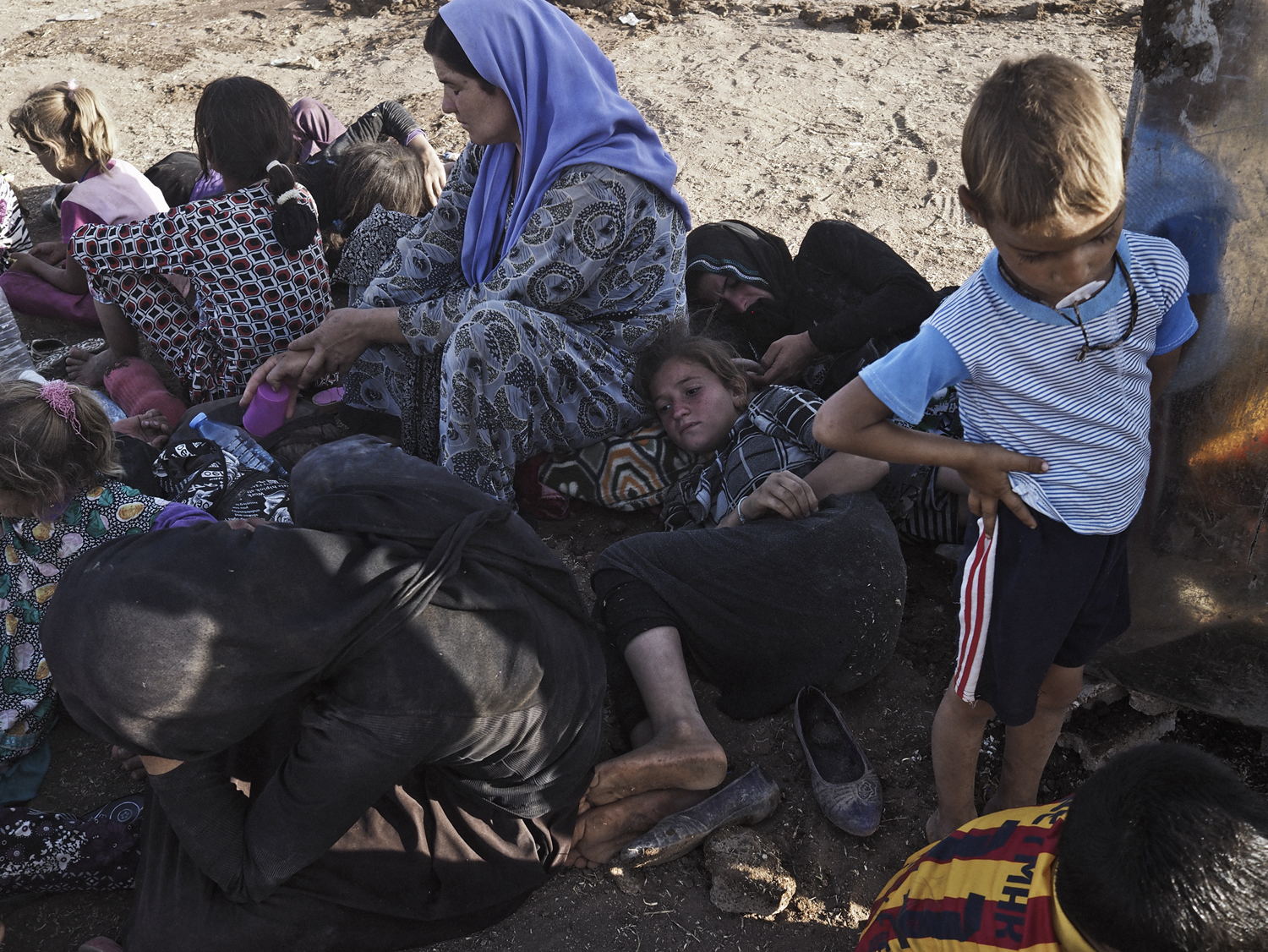 Aug. 10, 2014. Yezidi women and children from Sinjar, Iraq, rest at a makeshift camp on the outskirts of Derek, a Kurdish-controlled town in Syria that is located at the foot of the Sinjar Mountains along the border between Iraq and Syria. Derek, Syria.