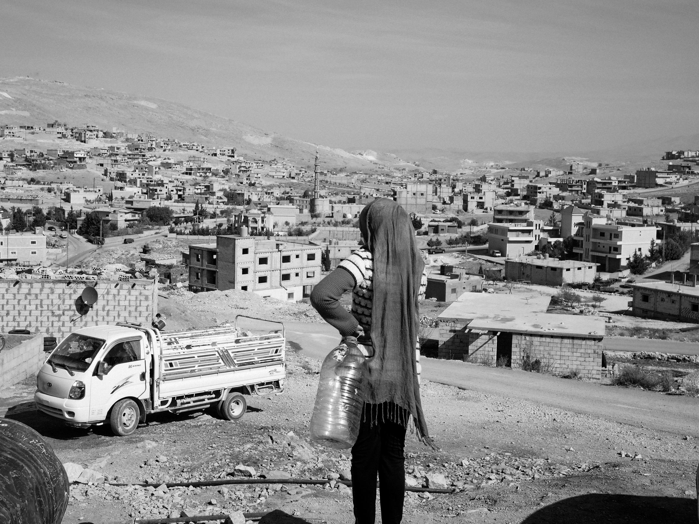 Arsal, Lebanon. November 6, 2013.A Syrian refugee on her way to fetch drinking water in the village of Arsal, Lebanon.(Photo by Moises Saman/MAGNUM)