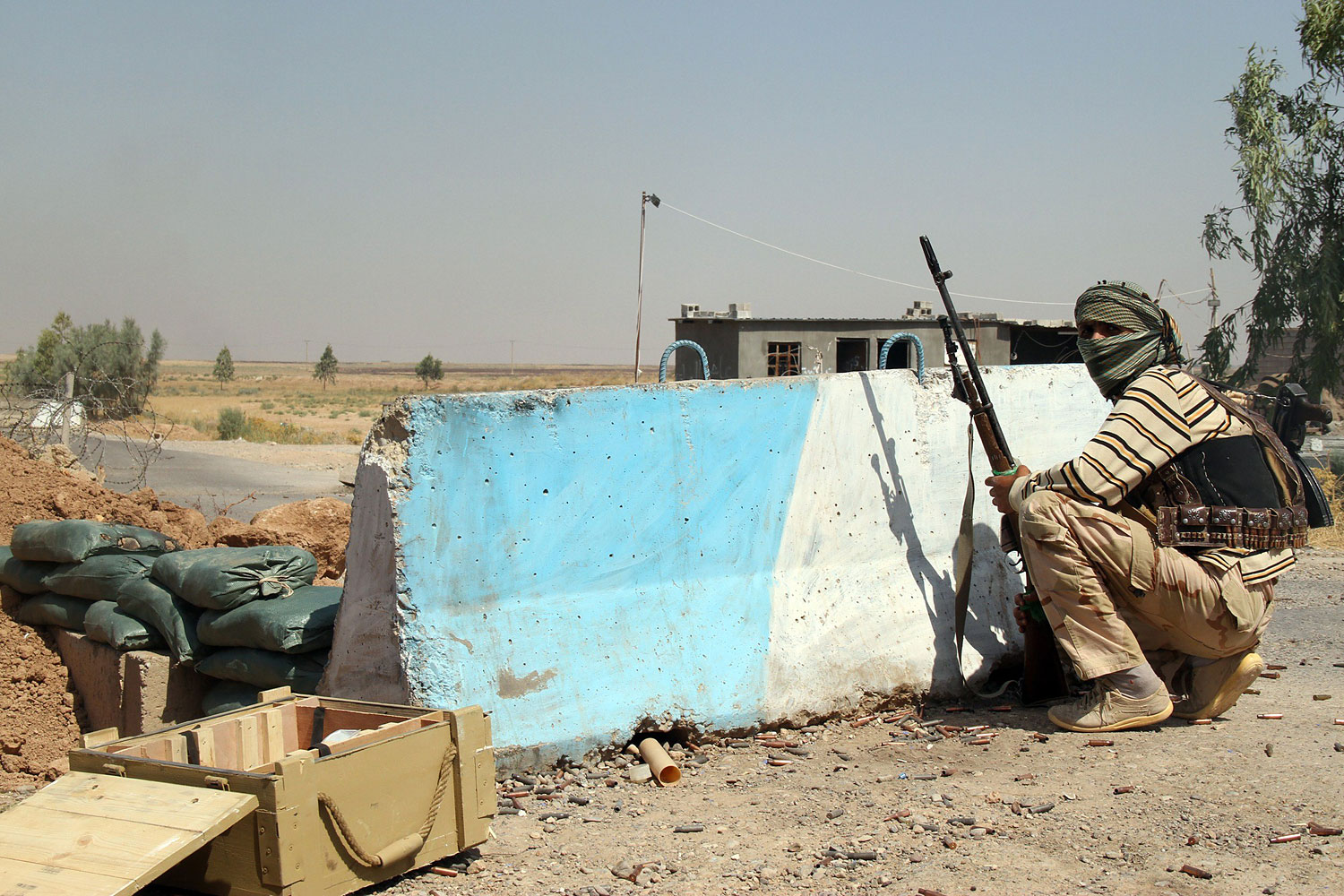 An Iraqi Turkmen Shi‘ite fighter holds a position on Aug. 4, 2014 in Amirli, Iraq (Ali Al-Bayati—AFP/Getty Images)