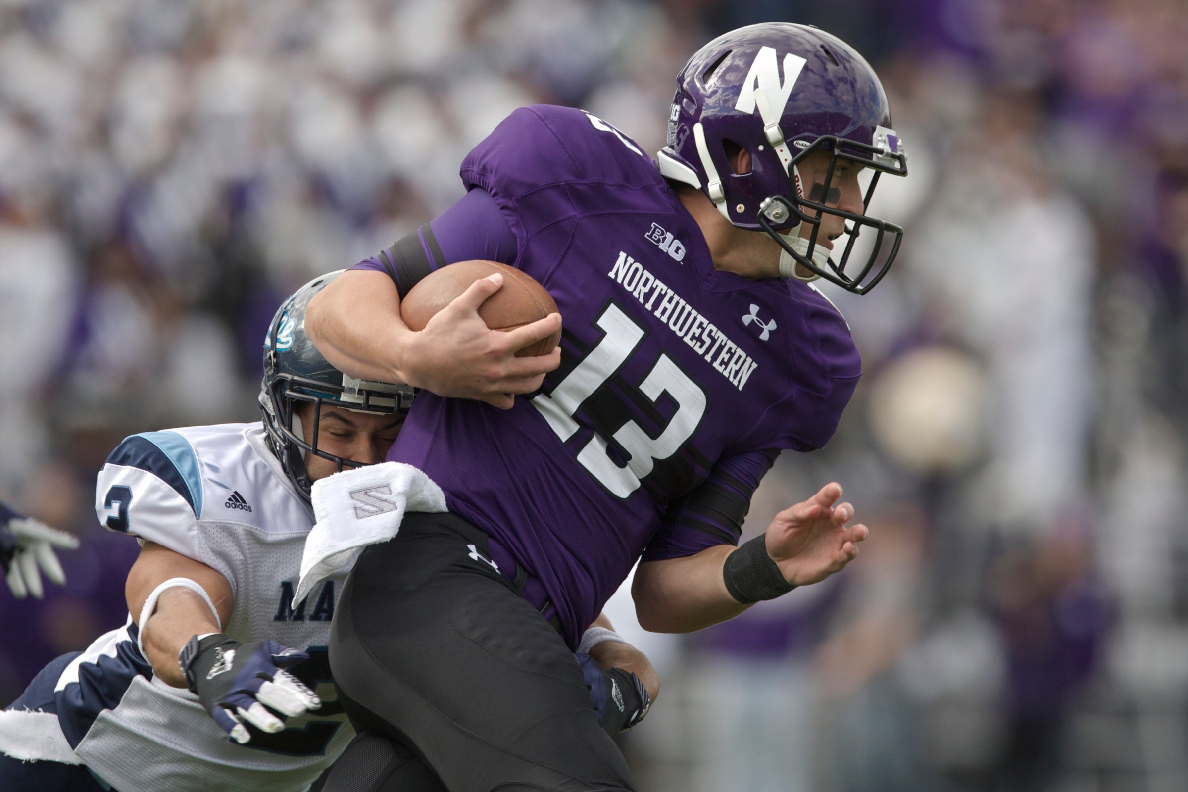 Cabrinni Goncalvesof the Maine Black Bears tackles Trevor Siemianof the Northwestern Wildcats during their college football game at Ryan Field on September 21, 2013 in Evanston, Illinois.