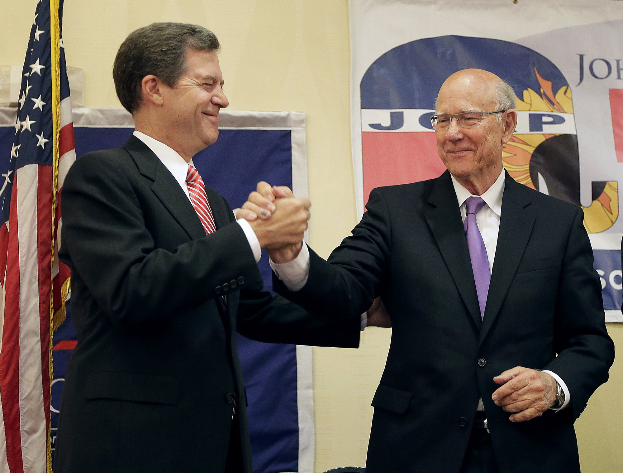 Kansas Gov. Sam Brownback, left, and U.S. Sen. Pat Roberts greet each other at Johnson County Republican's election watch party, Aug. 5, 2014, in Overland Park, Kan. (Charlie Riedel—AP)