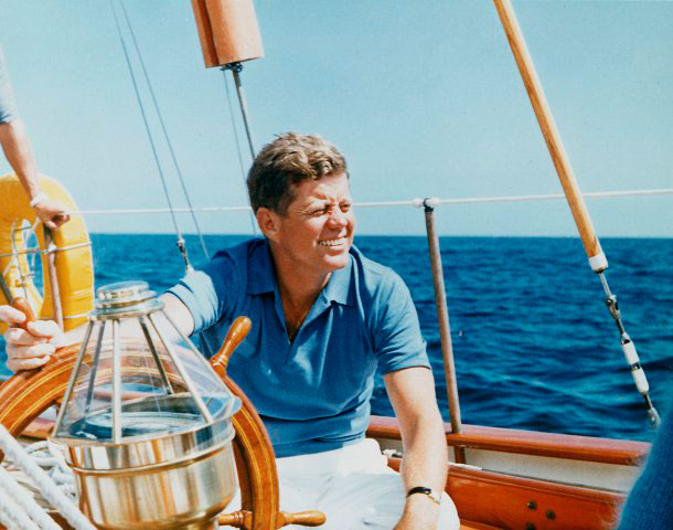 President Vacations at Hammersmith Farm. President Kennedy at the wheel of the Coast Guard Yacht "Manitou". Narragansett Bay, RI. 26 August 1962