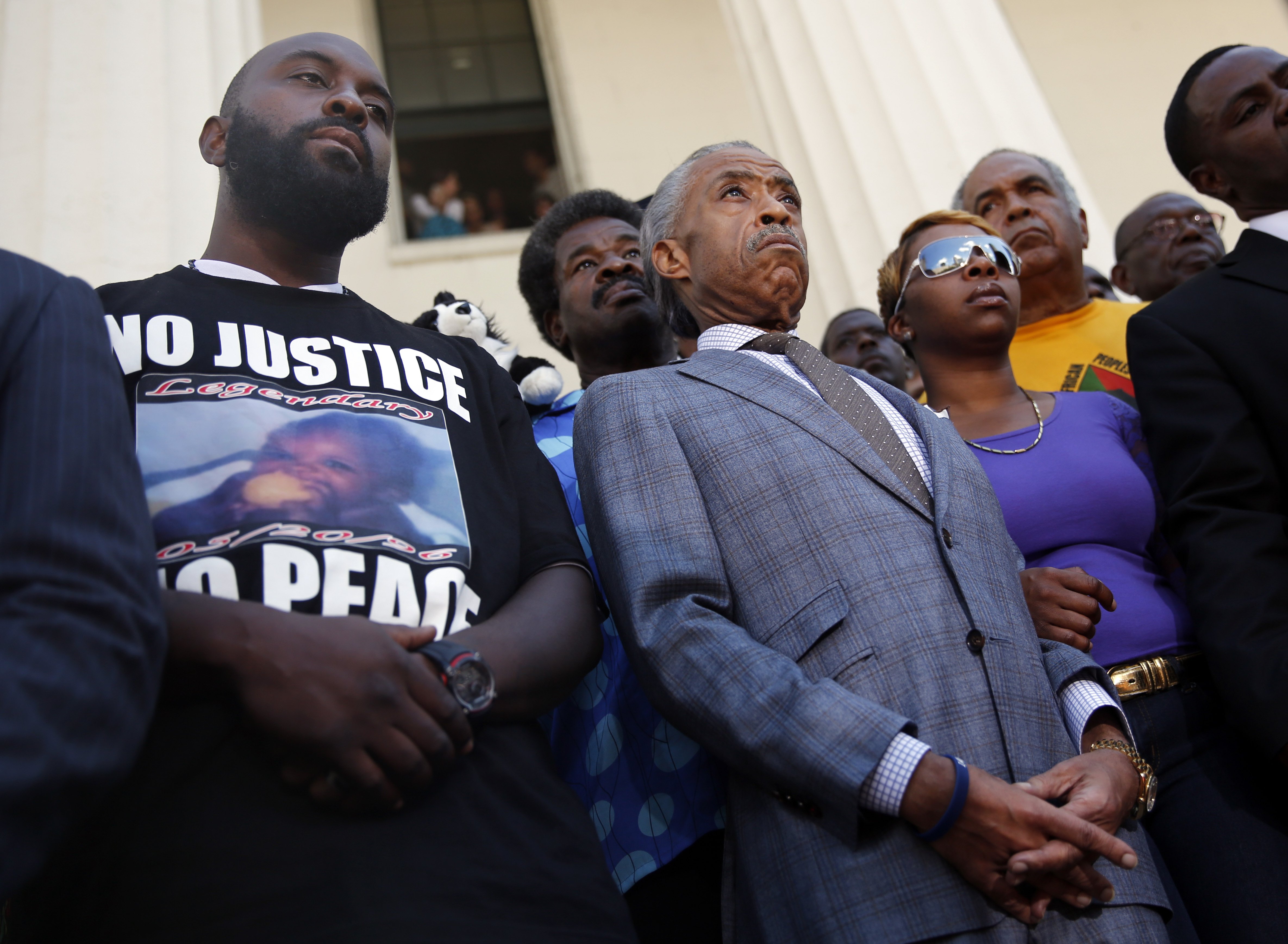 From left: Michael Brown, Sr., Reverend Al Sharpton, and Lesley McSpadden during a news conference outside the Old Courthouse in St. Louis on Aug. 12, 2014.
