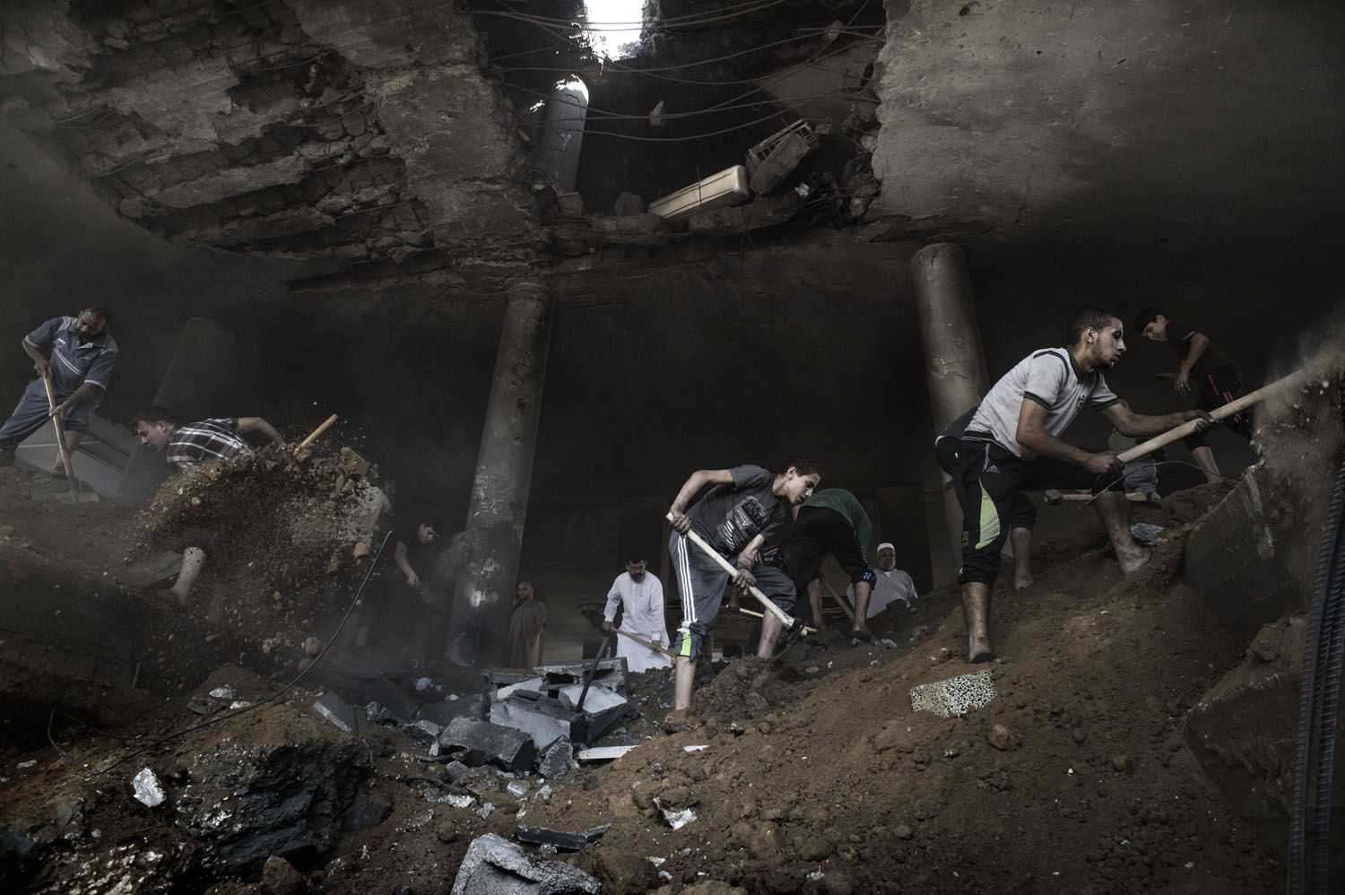 Aug. 9, 2014. Palestinians remove rubble in Martyr Imam Hassan al-banna mosque in Zeitoun neighborhood in Gaza City, following an overnight airstrike.