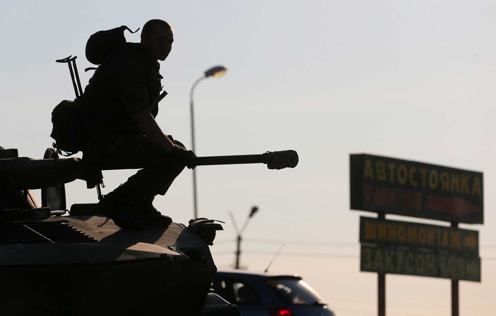 A Russian serviceman sits atop an armored vehicle outside Kamensk-Shakhtinsky, Russia's Rostov region, on Aug. 15, 2014. Dozens of heavy Russian military vehicles amassed on Friday near the border with Ukraine where a huge Russian convoy with humanitarian aid came to a halt as Moscow and Kiev struggled to agree border crossing procedures (Maxim Shemetov—Reuters)
