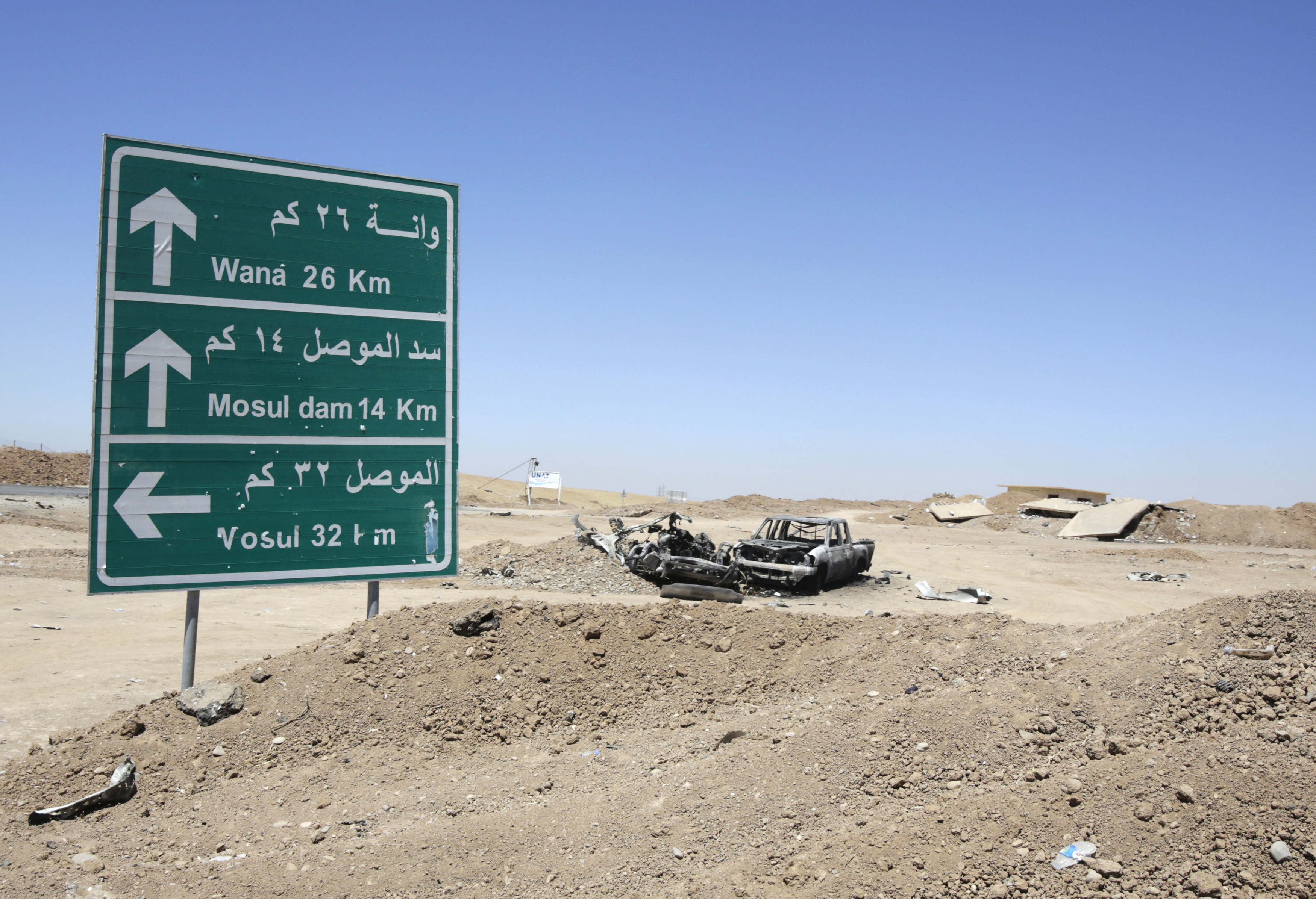 The wreckage of a car belonging to Islamic State militants lies along a road after it was targeted by a U.S. air strike at the entrance to the Mosul Dam