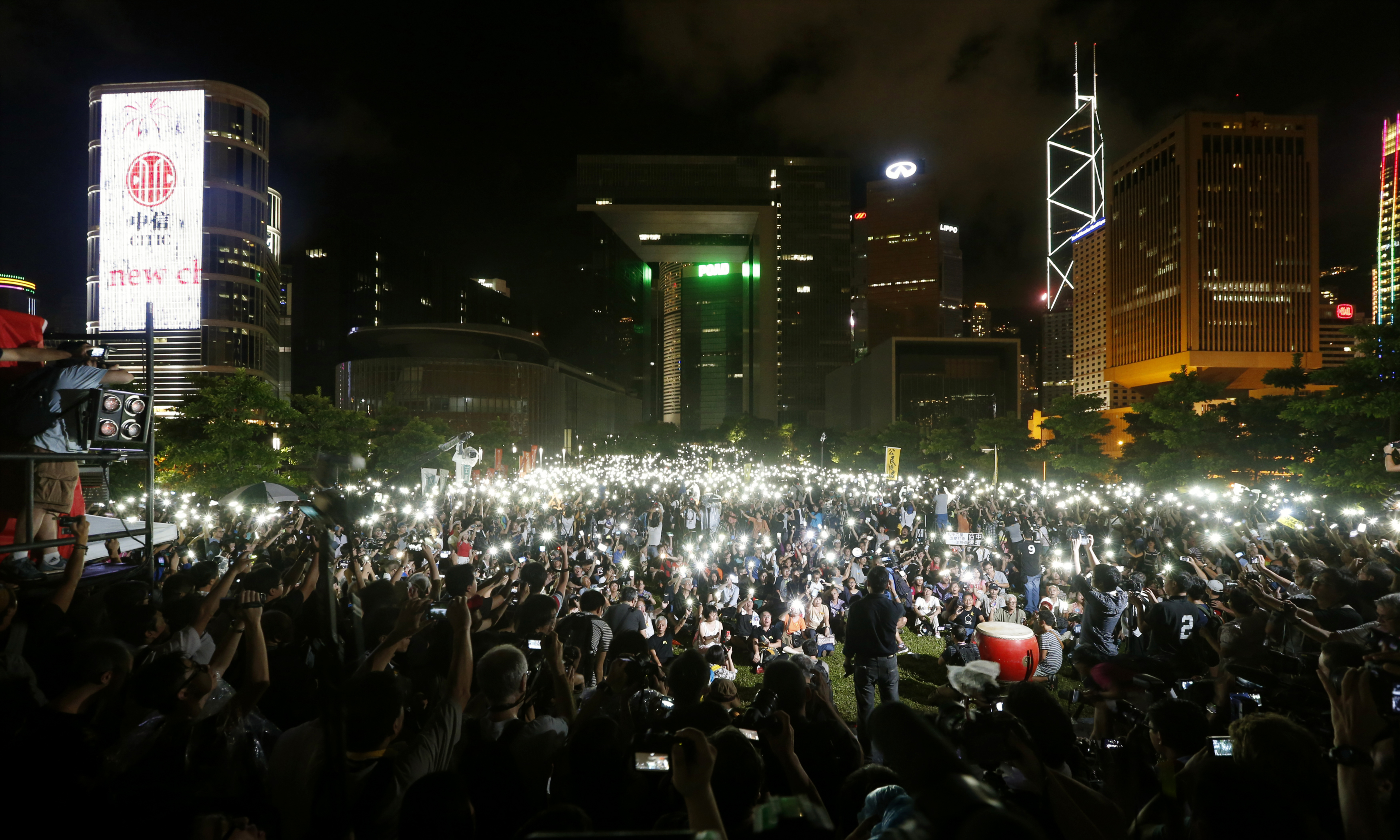 Pro-democracy protesters switch on their mobile phones during a campaign to kick off the Occupy Central civil disobedience event in Hong Kong