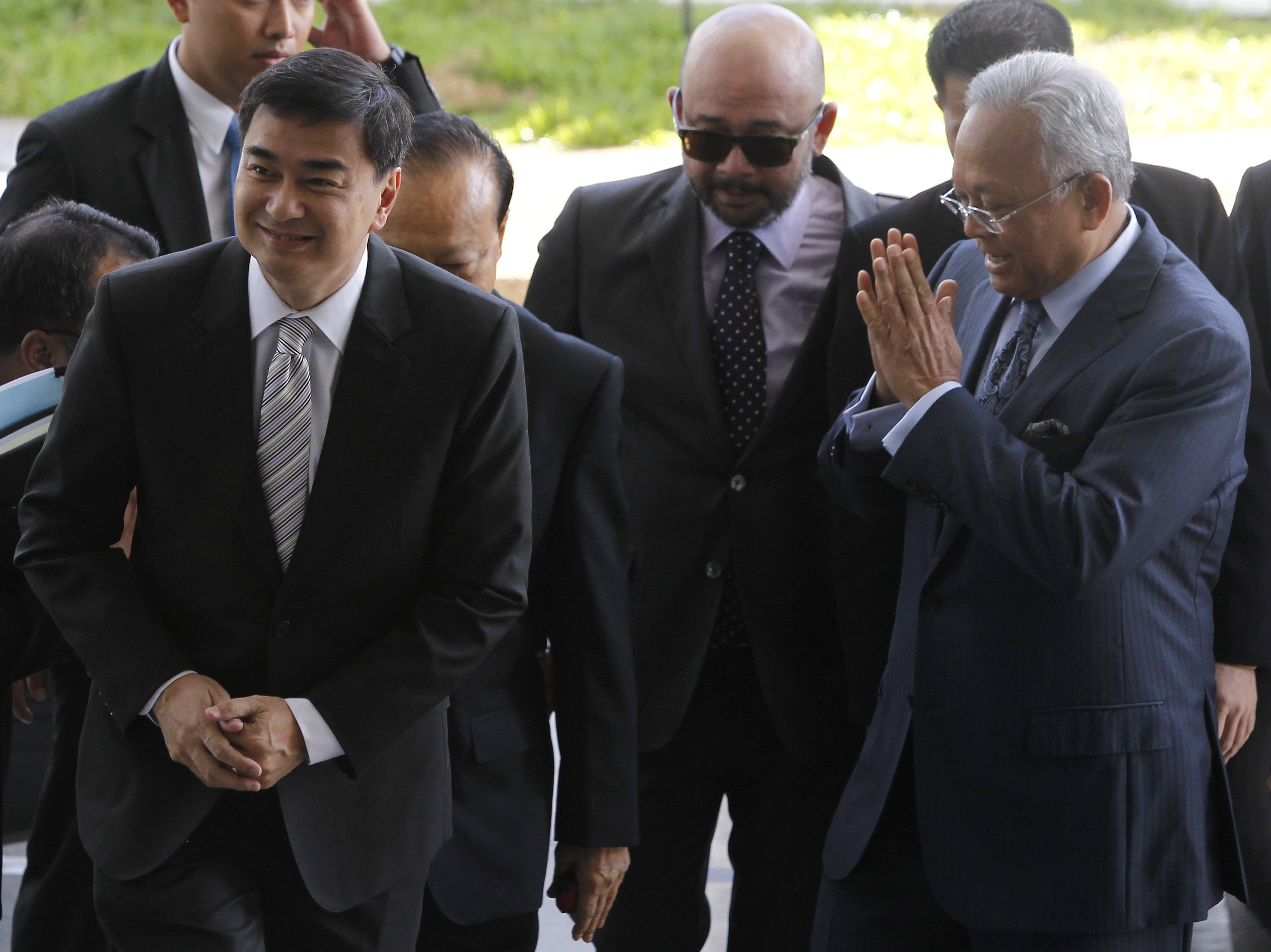 Former Thai Prime Minister Vejjajiva and his then deputy Thaugsuban arrive at the Department of Special Investigation in Bangkok