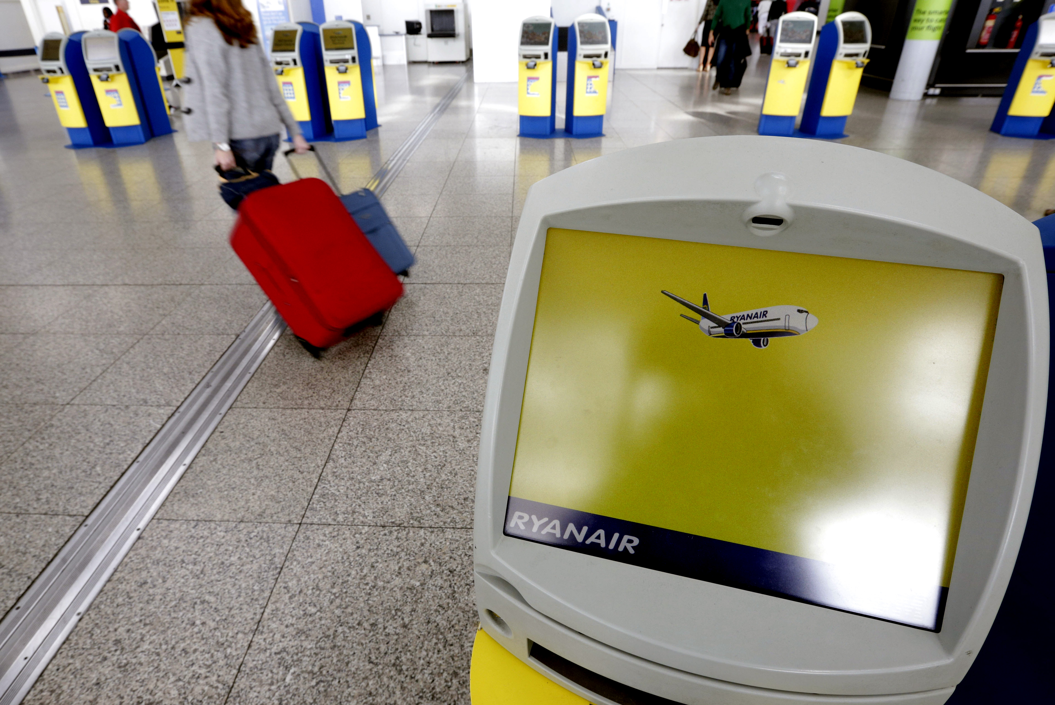 A passenger passes self-service check-in machines Ryanair Holdings Plc at Stansted Airport in London, U.K., on Wednesday, Aug. 7, 2013. (Bloomberg via Getty Images)