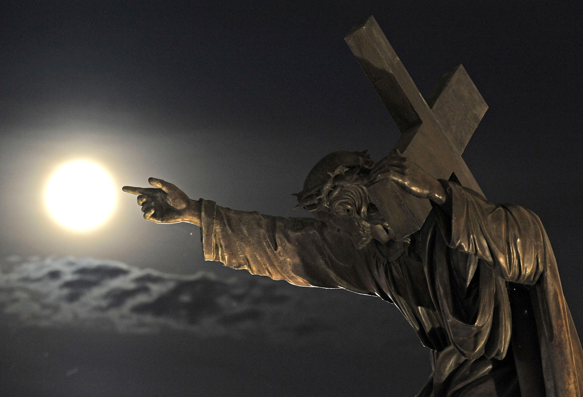 A supermoon rises above a Jesus Christ statue in front of the Holy Cross church in Warsaw, Poland on August 10, 2014.