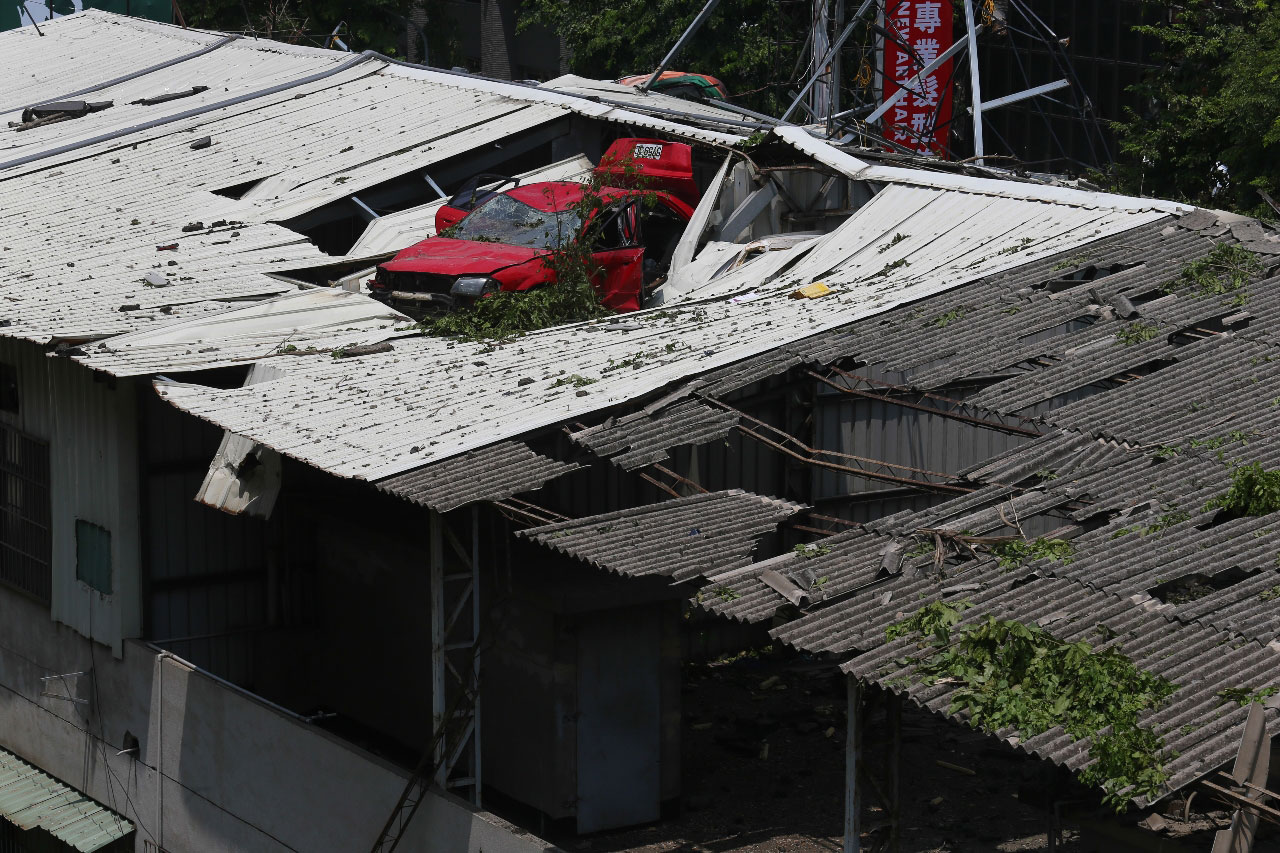 A car lands on top of a structure following an explosions that hit Kaohsiung city of Taiwan on July 31, 2013.