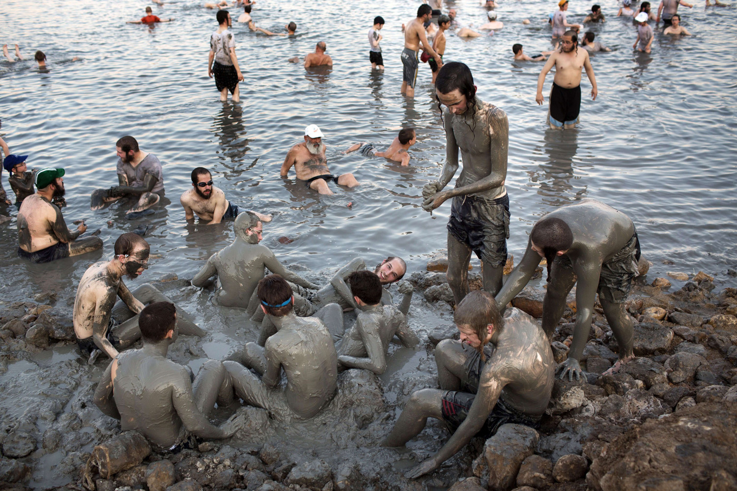 Aug. 17, 2014. Ultra-Orthodox Jewish men and boys cover their bodies with mineral-rich mud, during their vacation, at a Men's only beach on the shores of the northern part of the Dead Sea in the Israeli-occupied West Bank.