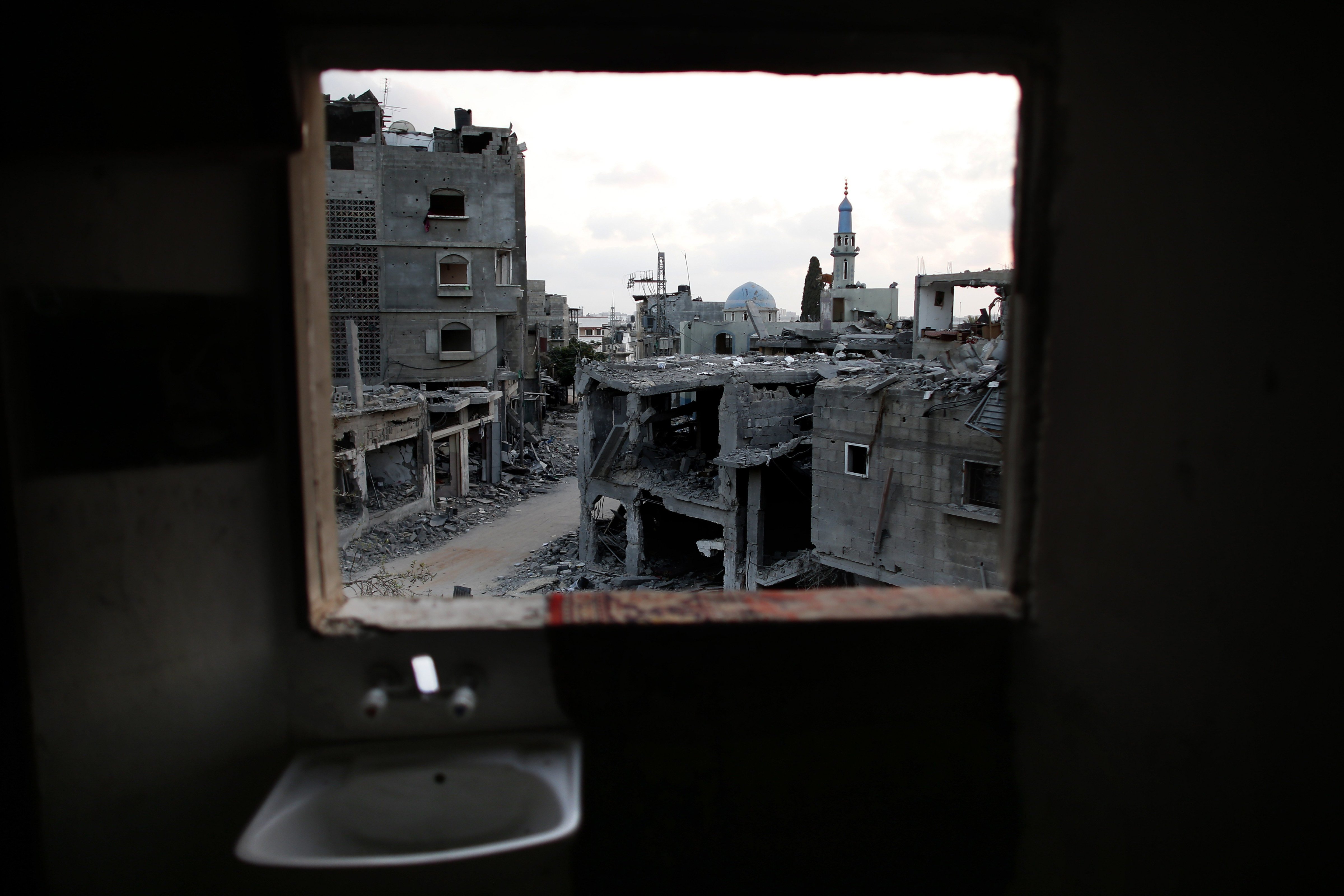 Destruction is seen from the bathroom of a Palestinian apartment in the northern Gaza Strip city of Beit Hanun, on August 18, 2014. (Thomas Coex—AFP/Getty Images)