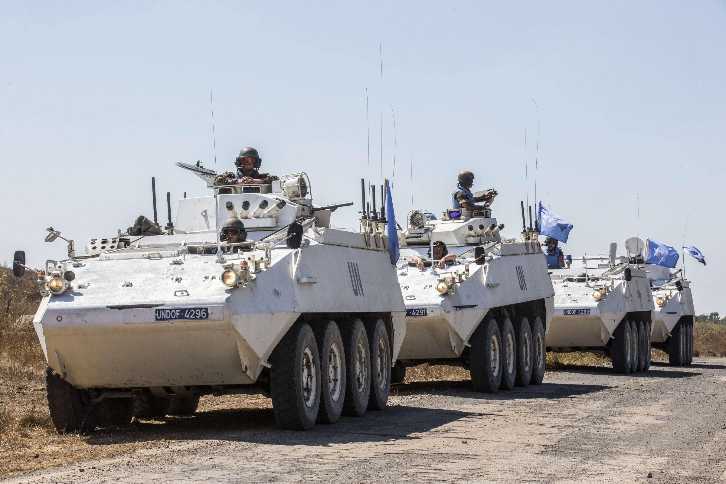 Irish members of the United Nations Disengagement Observer Force (UNDOF) sit on their armoured vehicles in the Israeli-annexed Golan Heights as they wait to cross into the Syrian-controlled territory, on August 28, 2014.