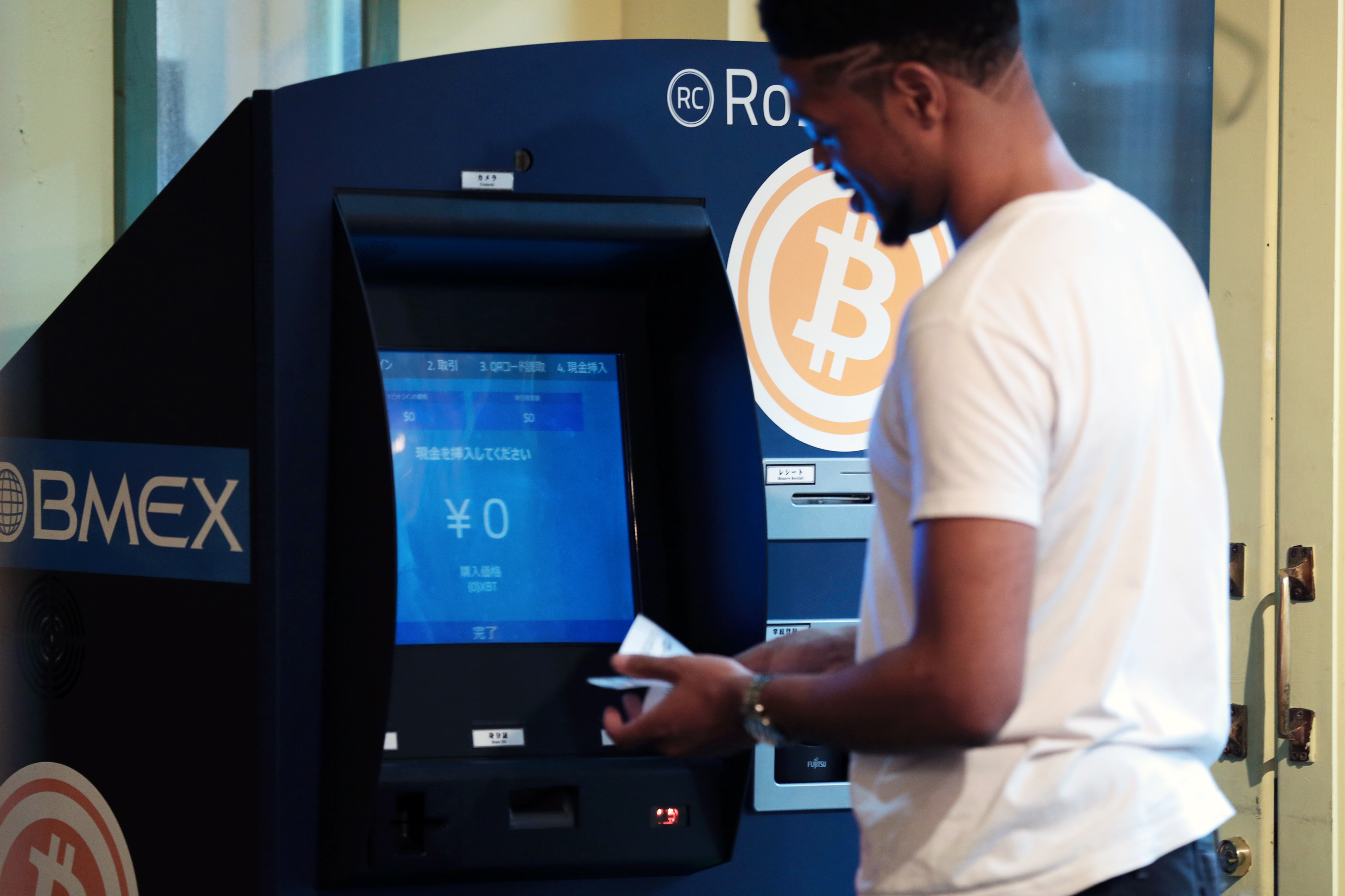 A customer purchases bitcoins from the BMEX bitcoin exchange's Robocoin-branded ATM in Tokyo, Japan, on Wednesday, June 18, 2014. (Bloomberg via Getty Images)