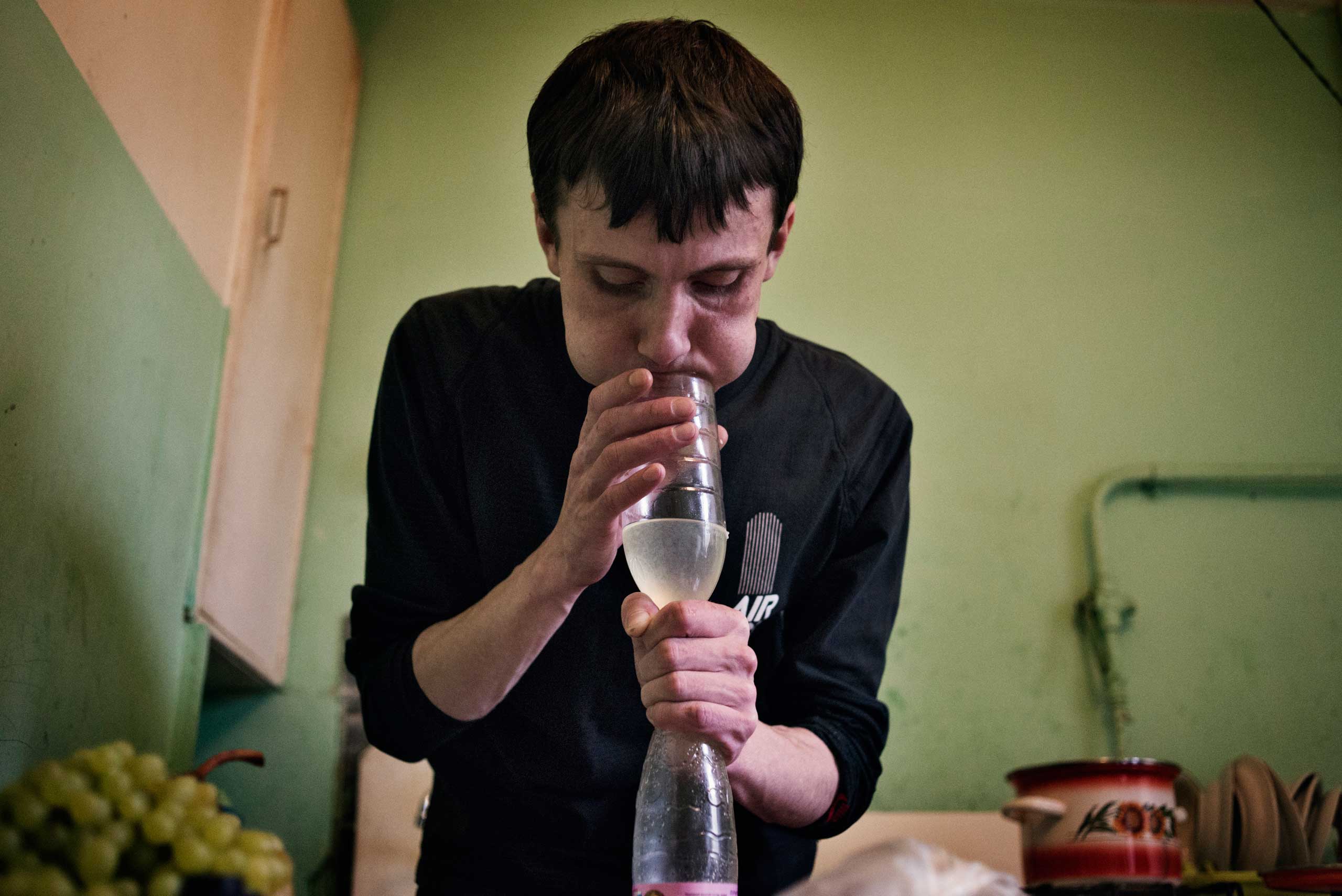 Alexey, 30 years old, blows air in a bottle to push the liquid through a filter and use it to prepare the krokodil.