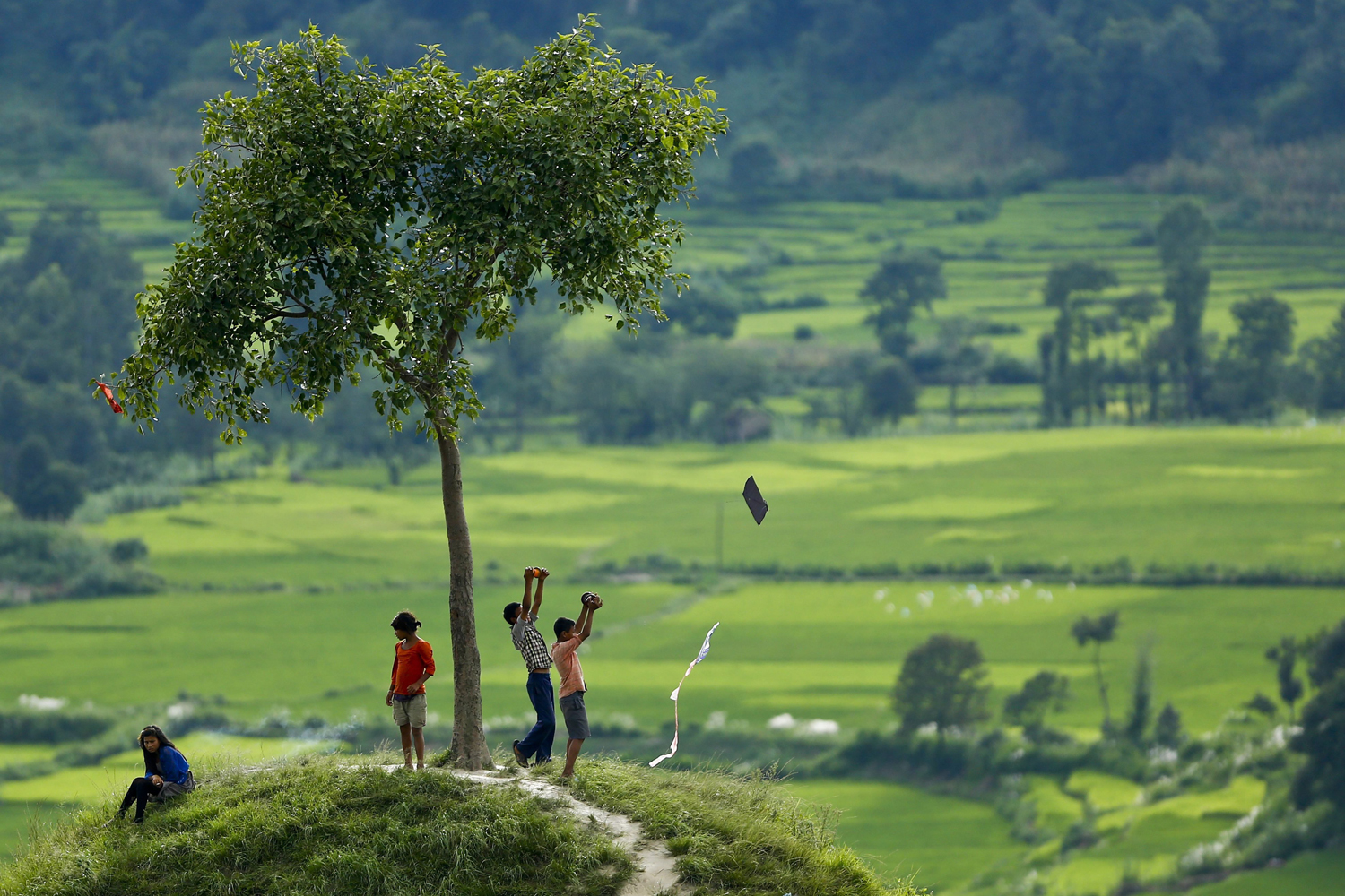 Sept. 7, 2014. Nepalese children fly a kite from a hill in the fields surrounding the Khokana village near Kathmandu, Nepal. According to Hindu mythology, Nepalese start flying kites after rains have stopped and finishing the summer season with the message to spread that 'monsoon is over'.