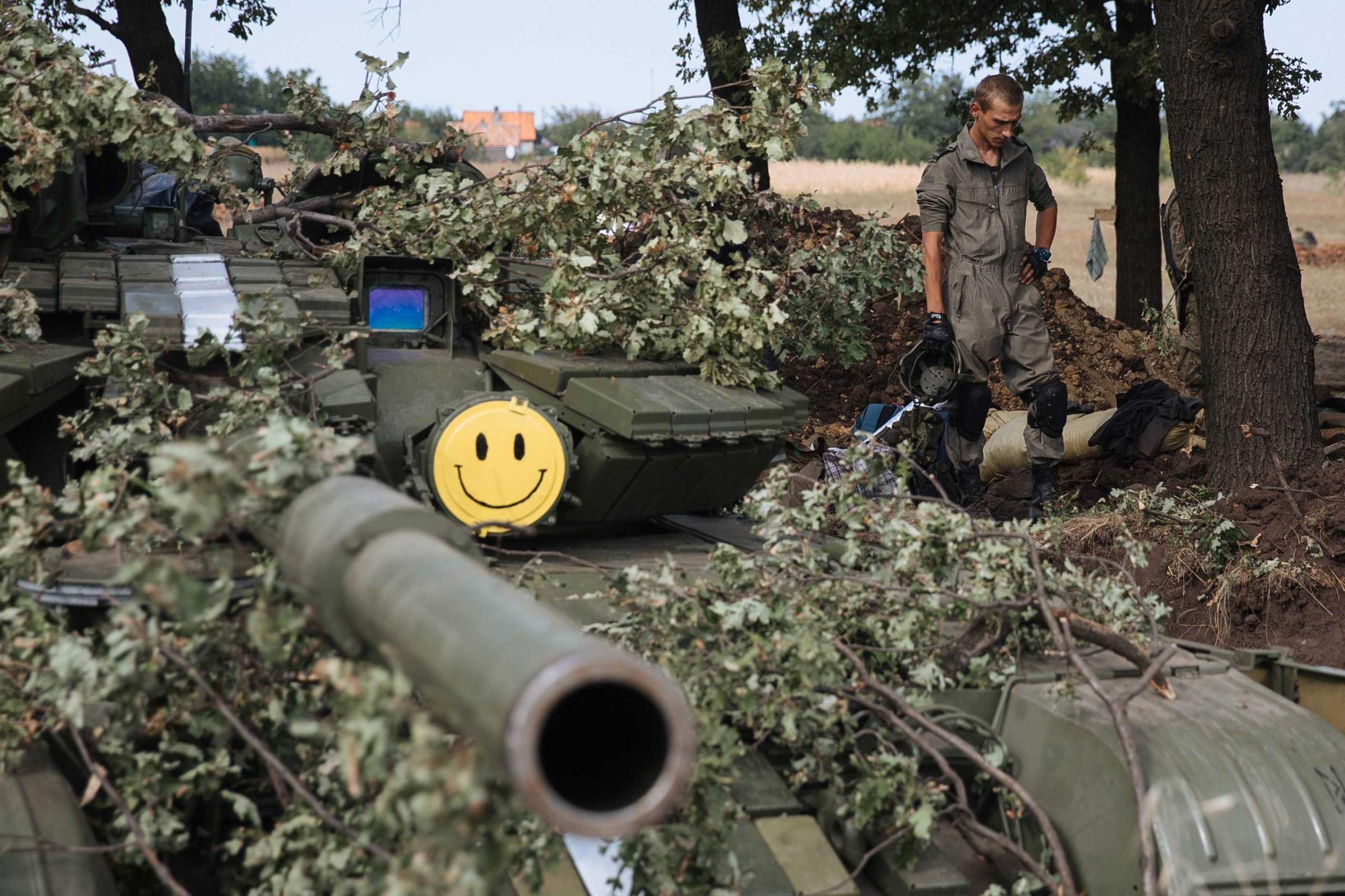 Ukrainian fighters partly wearing non-official uniforms stands next to a tank in a military camp based on a front line near Pervomaysk city of Lugansk region, Ukraine on Sept 12, 2014.
