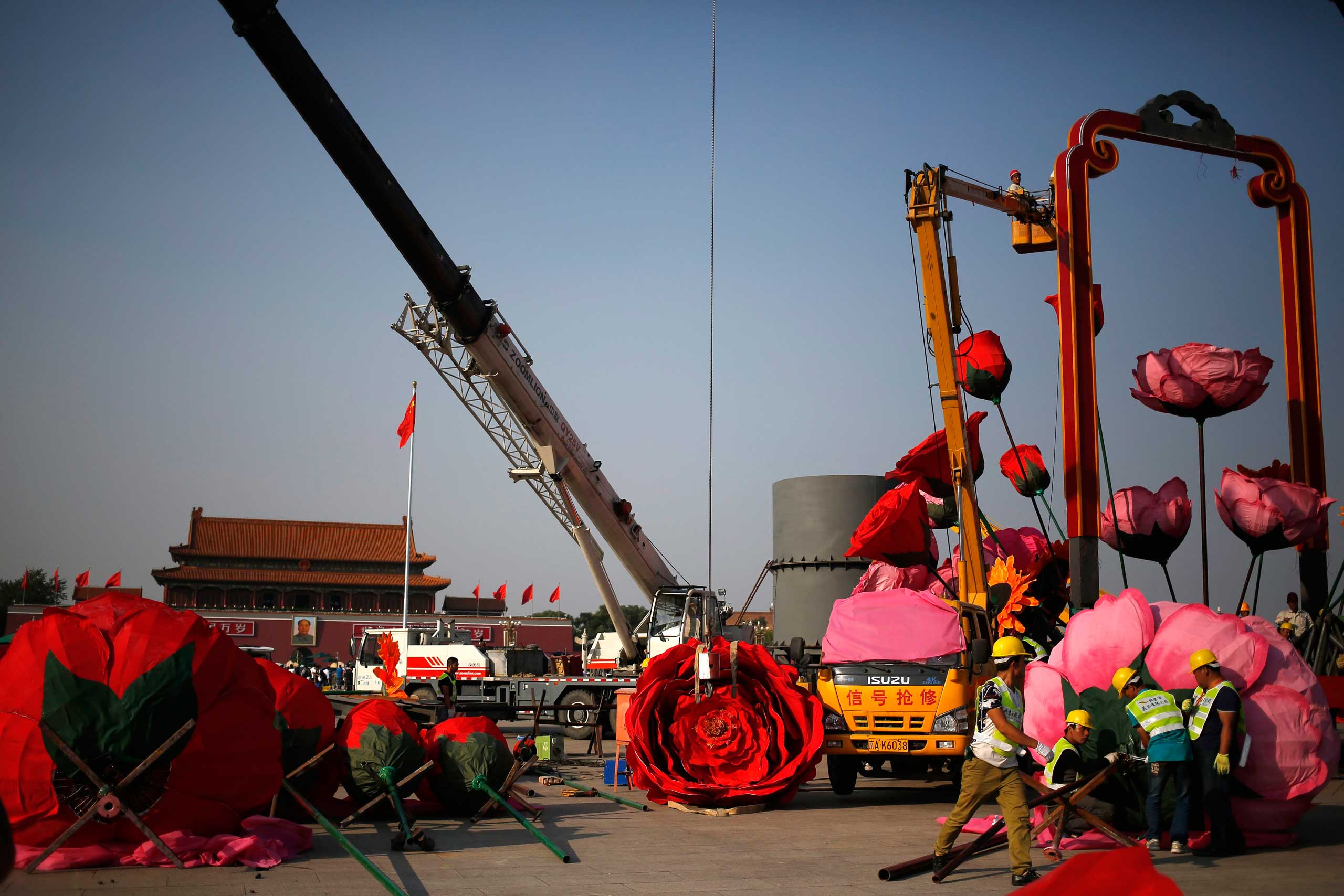 Sept. 18,  2014. Chinese workers set up giant decoration flowers in preparations for National Day at Tiananmen Square in Beijing.