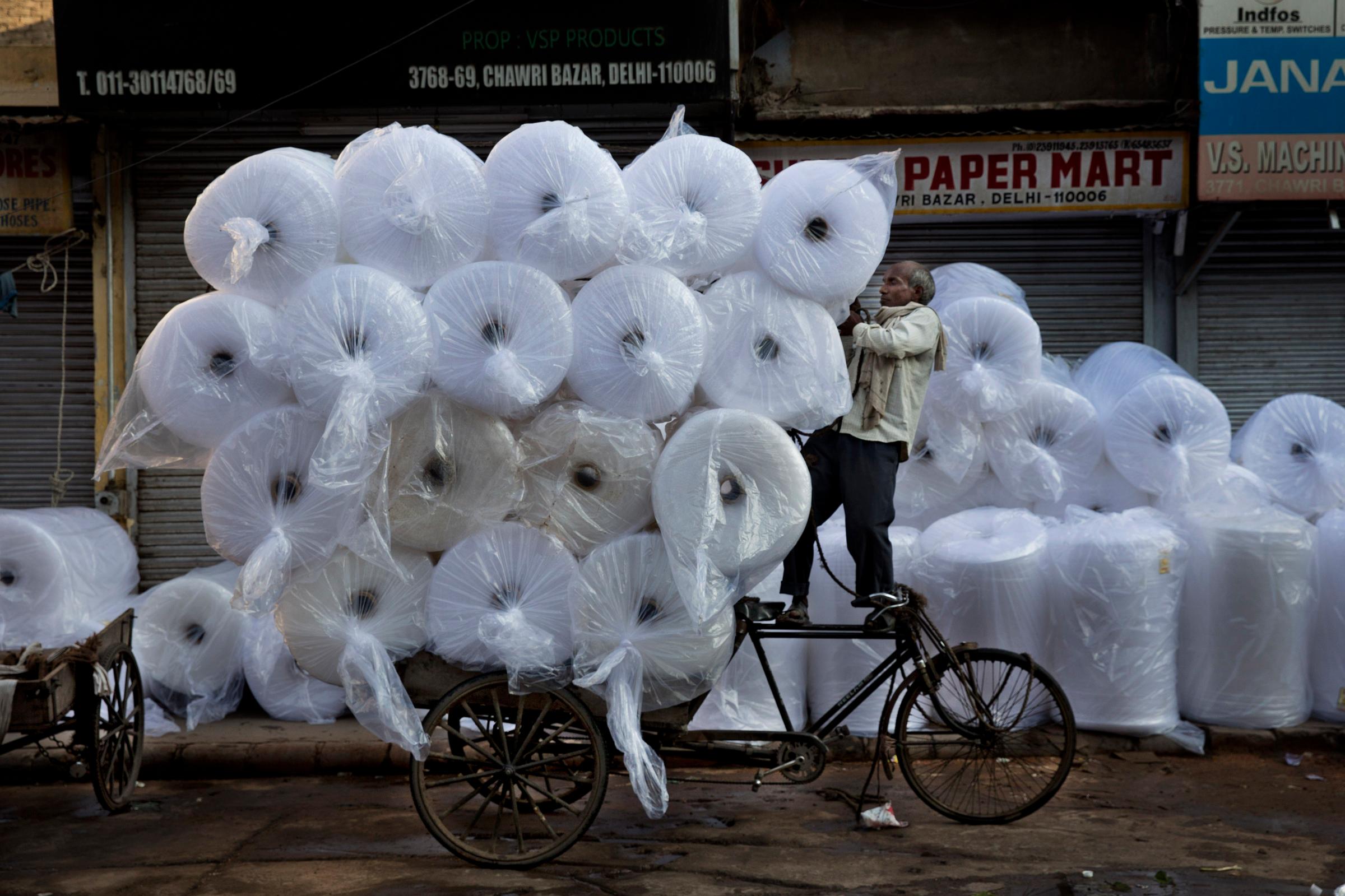 An Indian laborer loads goods on a bike at Chawri Bazar, in New Delhi on Sept. 1, 2014.