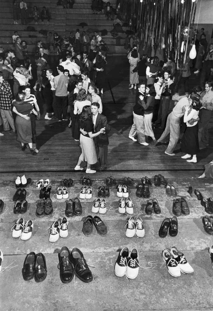 Sock hops are current craze in Oklahoma City. Boys and girls at school gym dances check shoes outside to avoid marking gym floor. Dancing is fun, but someone always goes home wearing the wrong shoes.