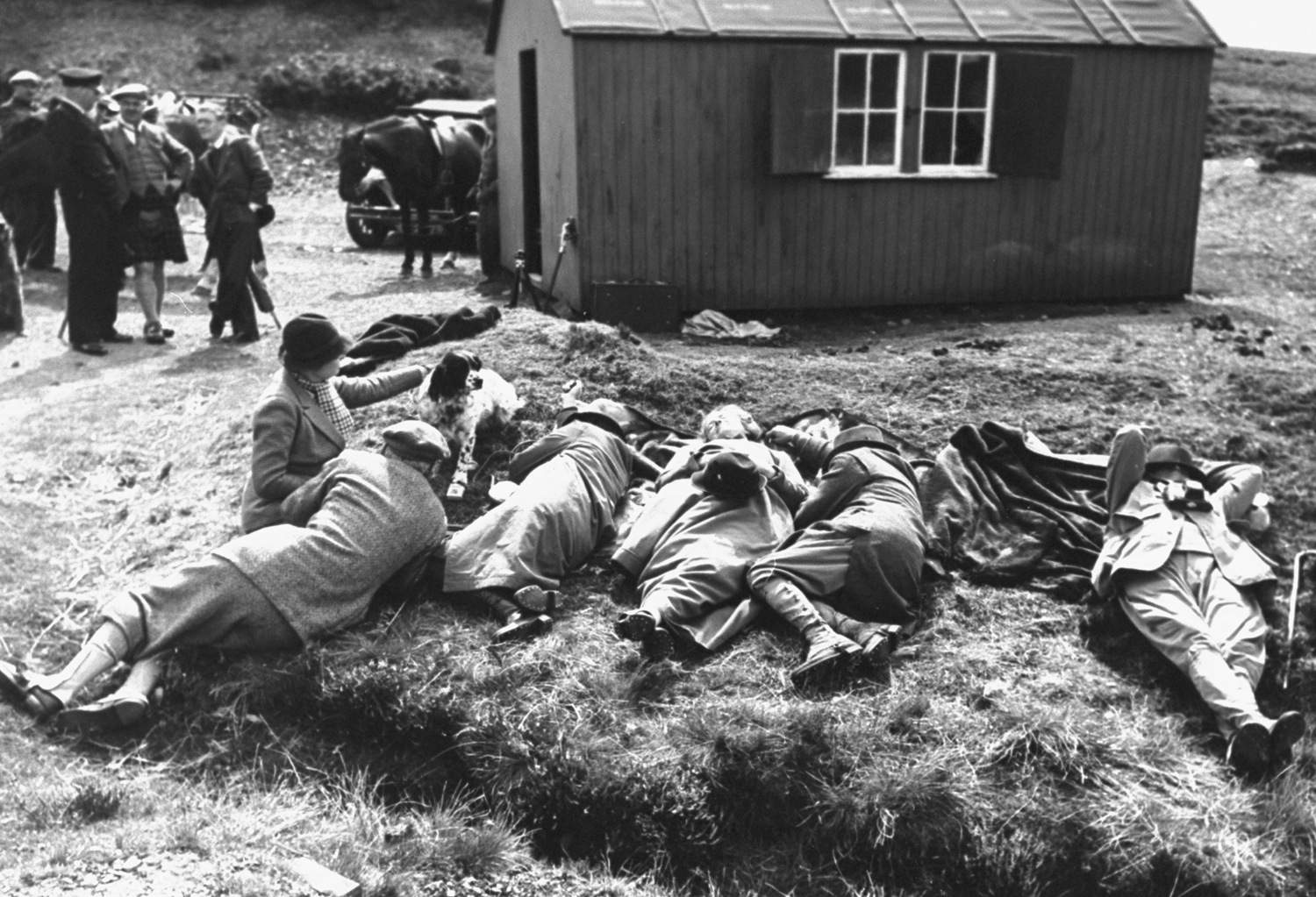 Hunters take a nap on the grass after lunch, 1938.